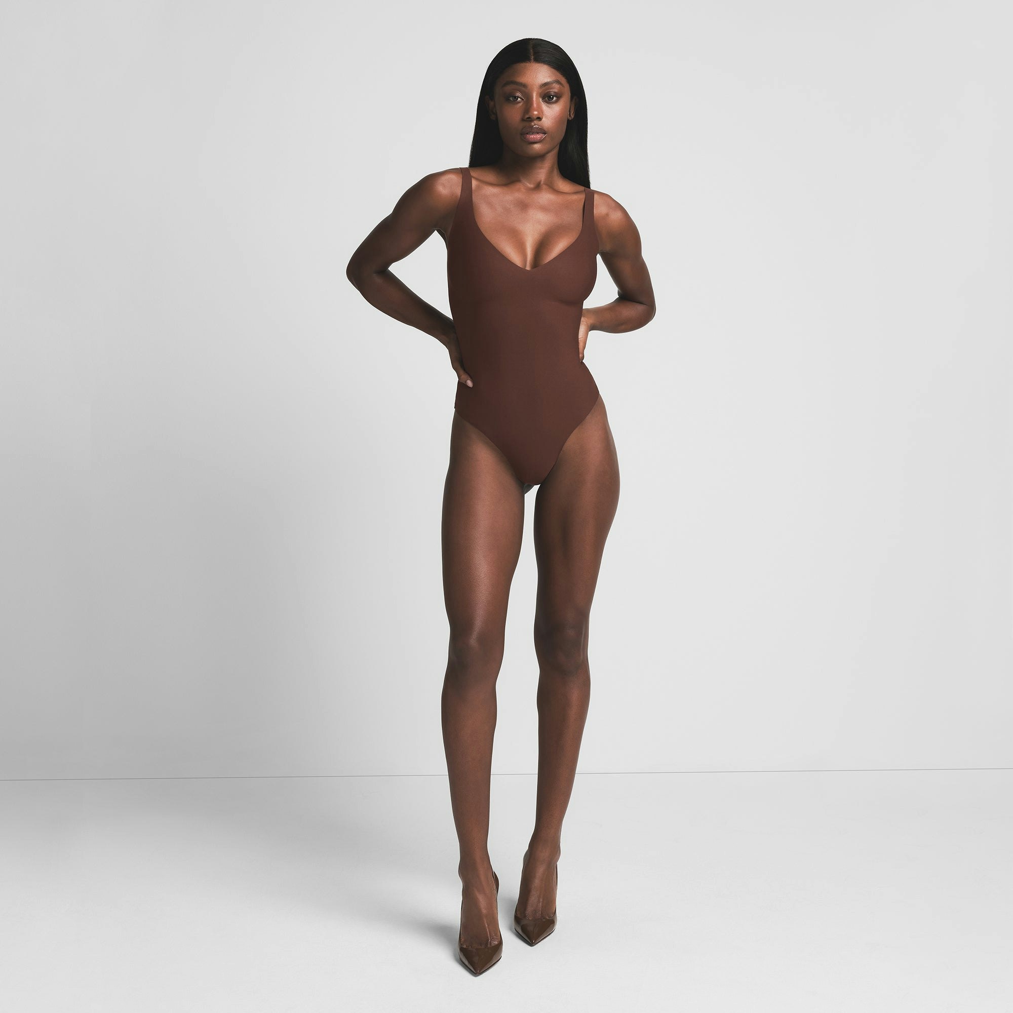 SKIMS BODY UNLINED PLUNGE THONG BODYSUIT | COCOA ON A MODEL FRONT VIEW | FOCUS: 0.0, 1.0, 0.9
