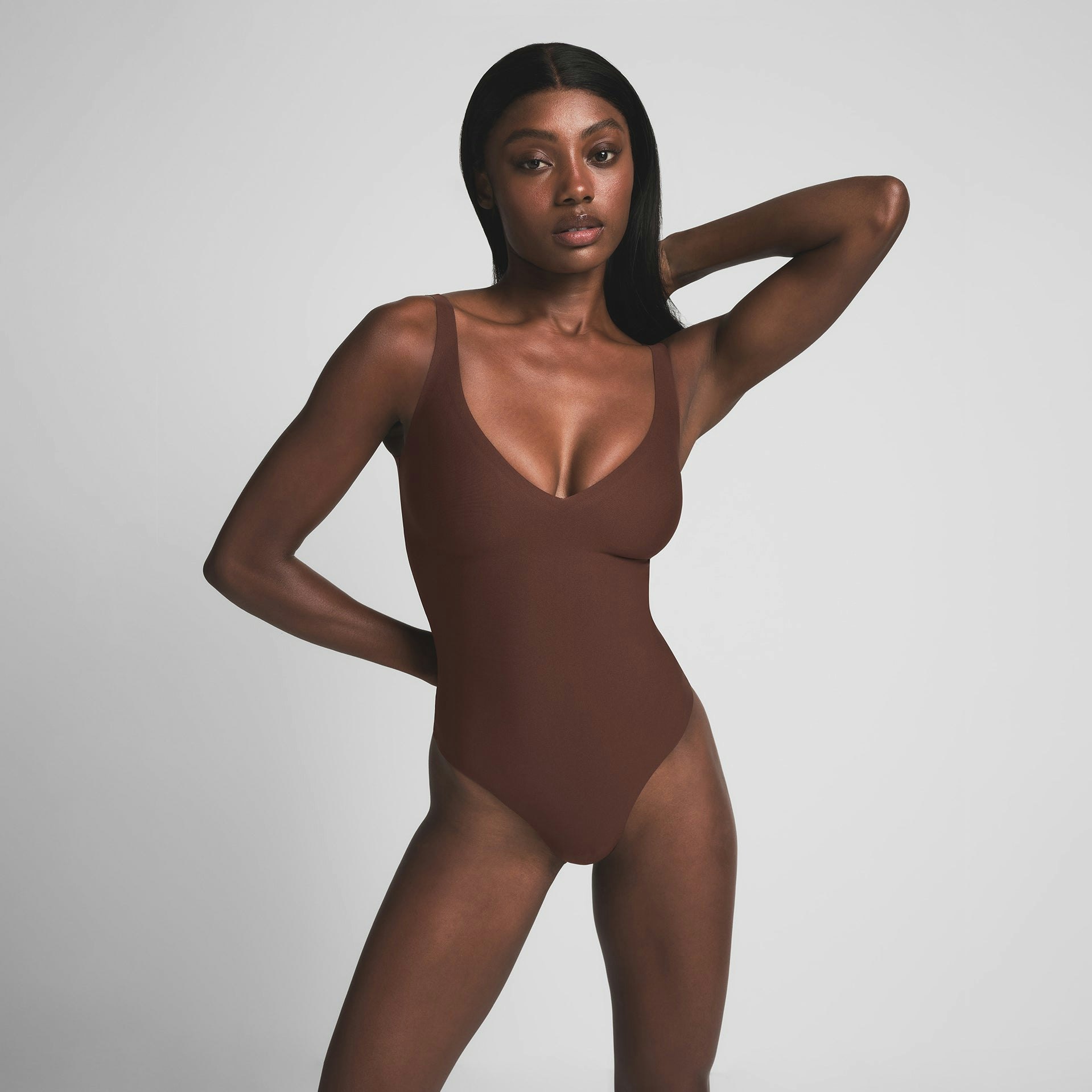 SKIMS BODY UNLINED PLUNGE THONG BODYSUIT | COCOA ON A MODEL FRONT VIEW | FOCUS: 0.0, 1.0, 0.9