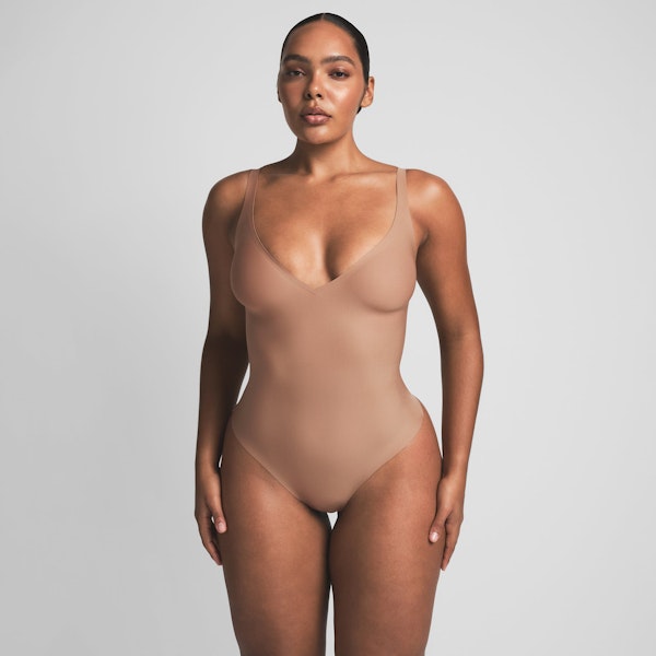 SKIMS BODY UNLINED PLUNGE THONG BODYSUIT | SIENNA ON A MODEL FRONT VIEW | FOCUS: 0.0, 1.0, 0.9