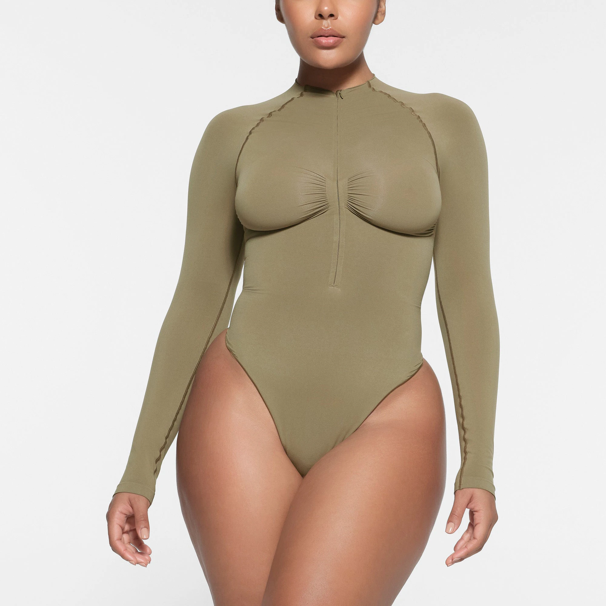 SEAMLESS SCULPT HALF ZIP LONG SLEEVE THONG BODYSUIT | ARMY ON A MODEL FRONT VIEW