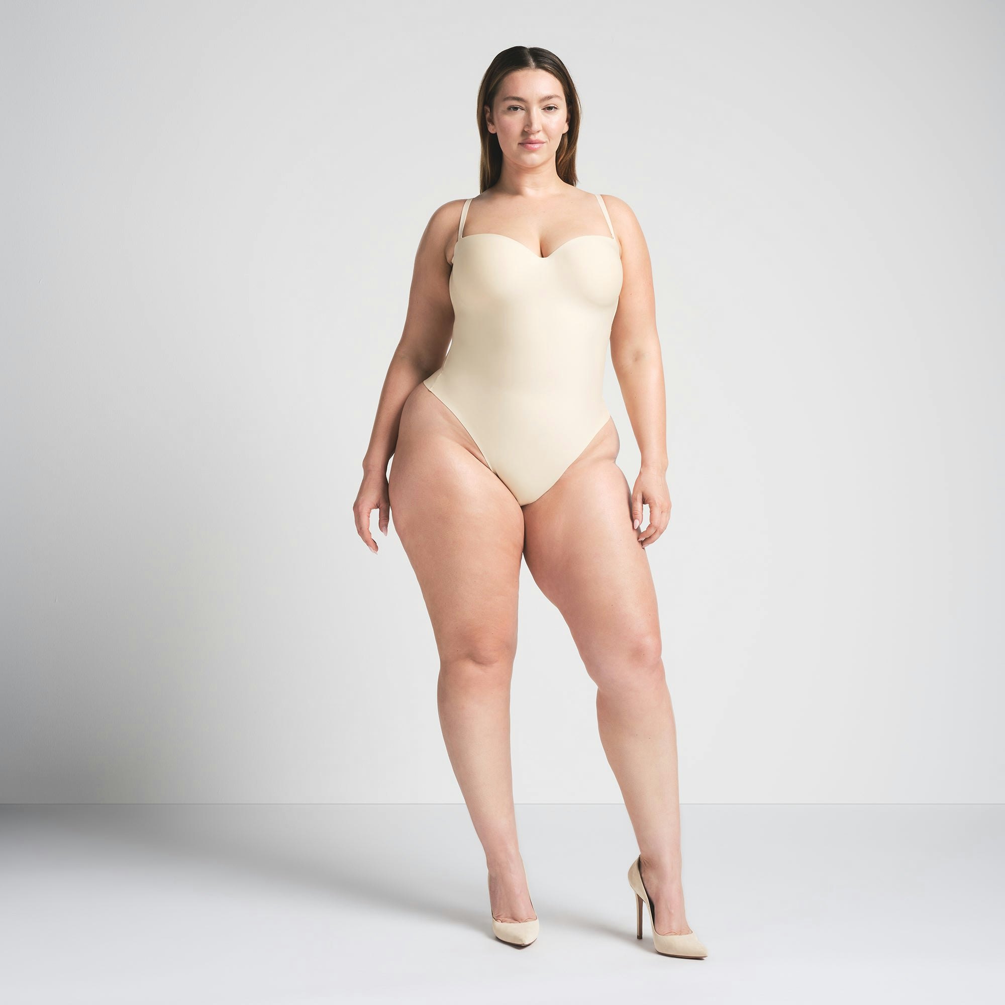 SKIMS BODY UNDERWIRE THONG BODYSUIT | SAND ON A MODEL FRONT VIEW @ | FOCUS: 0.0, 1.0, 0.9
