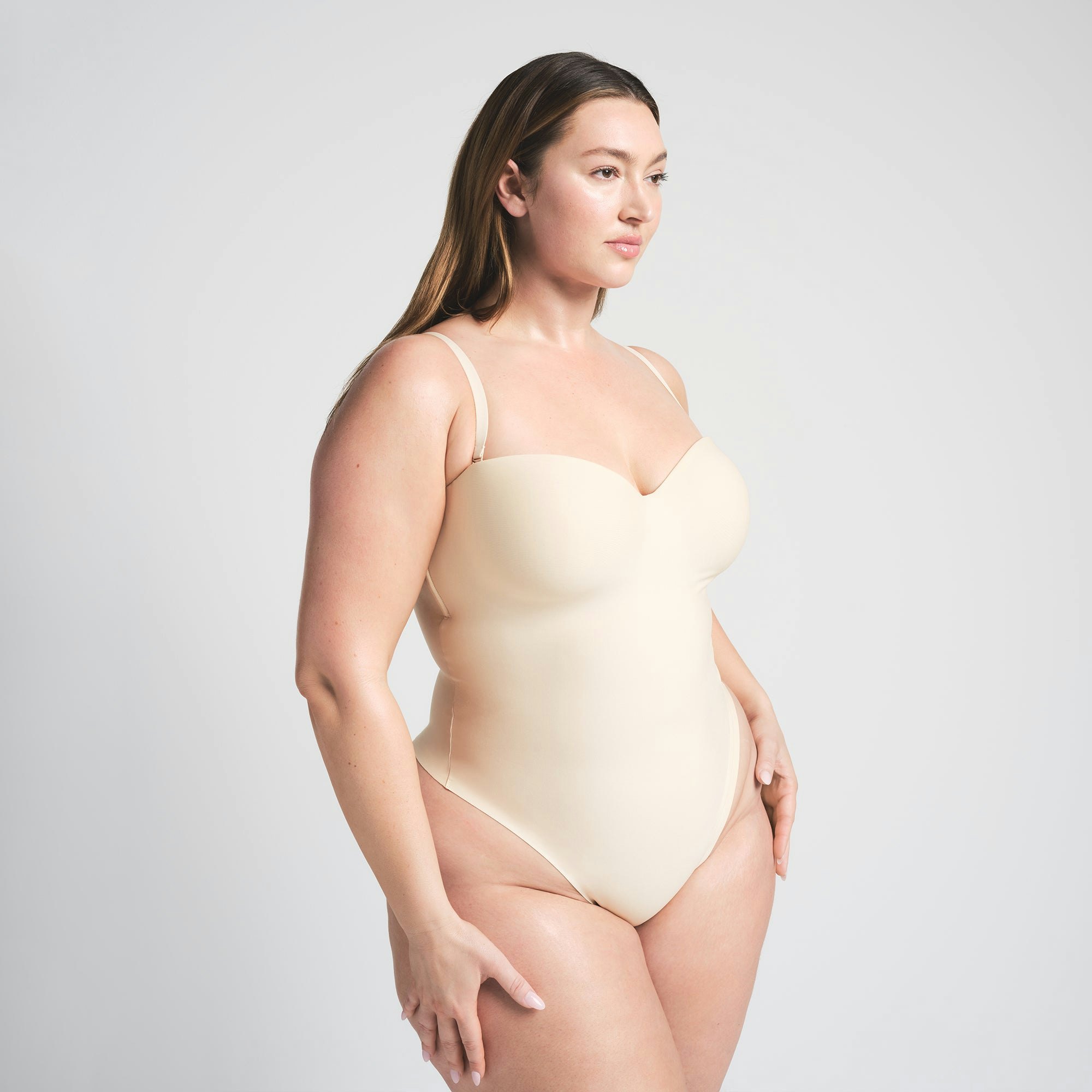 SKIMS BODY UNDERWIRE THONG BODYSUIT | SAND ON A MODEL SIDE VIEW @ | FOCUS: 0.0, 1.0, 0.9