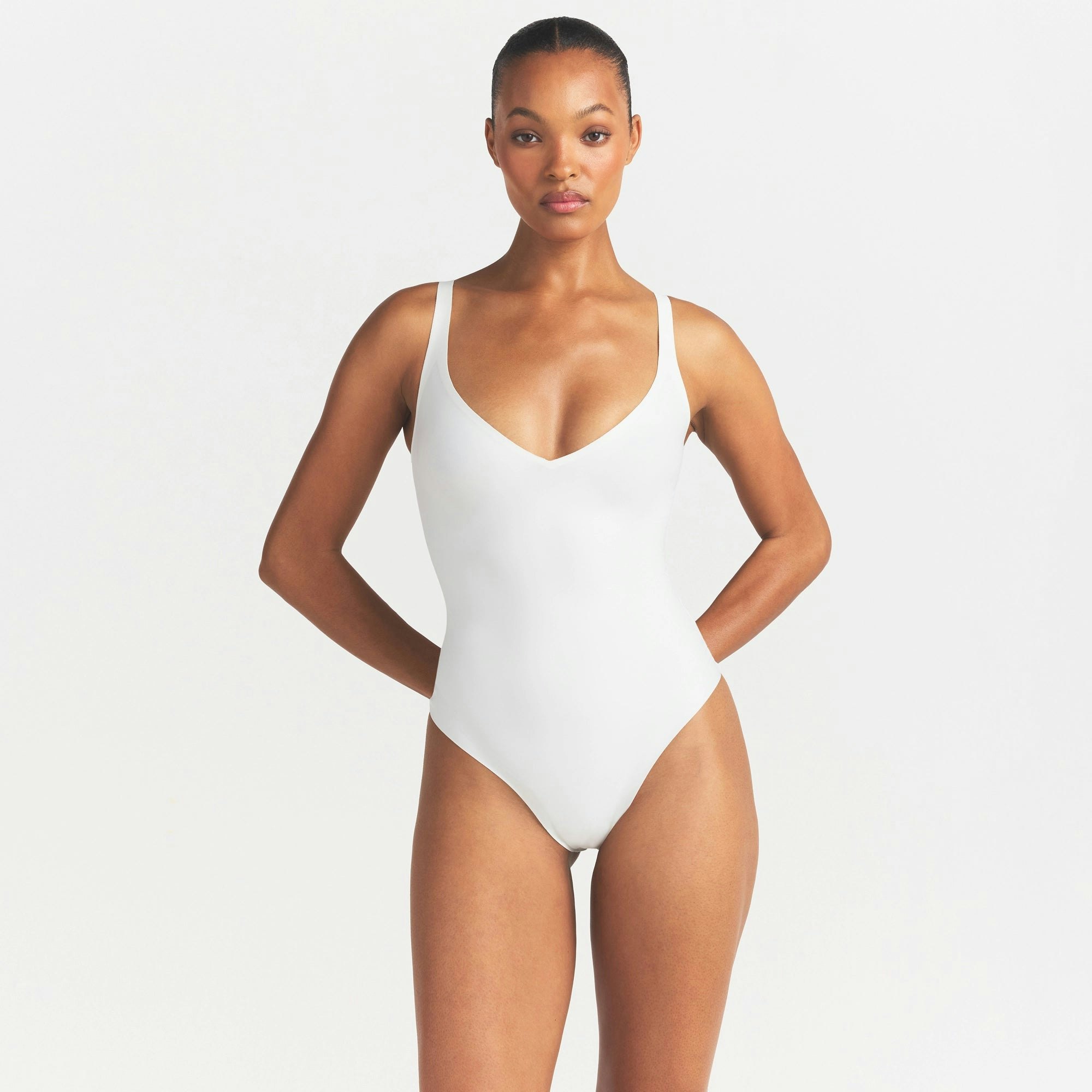 SKIMS BODY UNLINED PLUNGE THONG BODYSUIT | IVORY ON A MODEL SIDE VIEW @ | FOCUS: 0.0, 1.0, 0.9