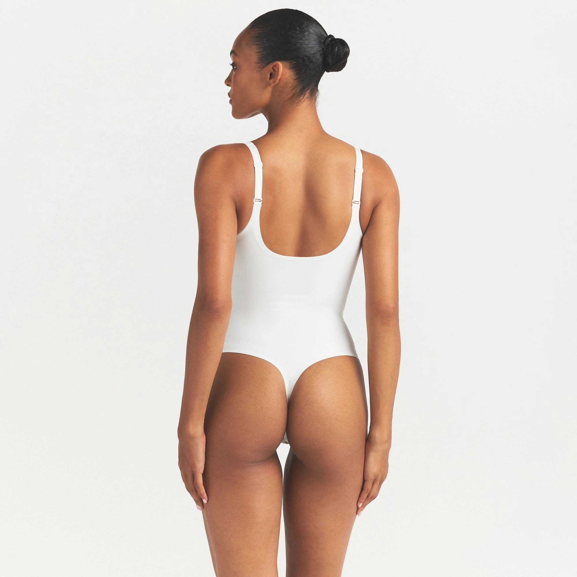 SKIMS BODY UNLINED PLUNGE THONG BODYSUIT | IVORY ON A MODEL SIDE VIEW @ | FOCUS: 0.0, 1.0, 0.9