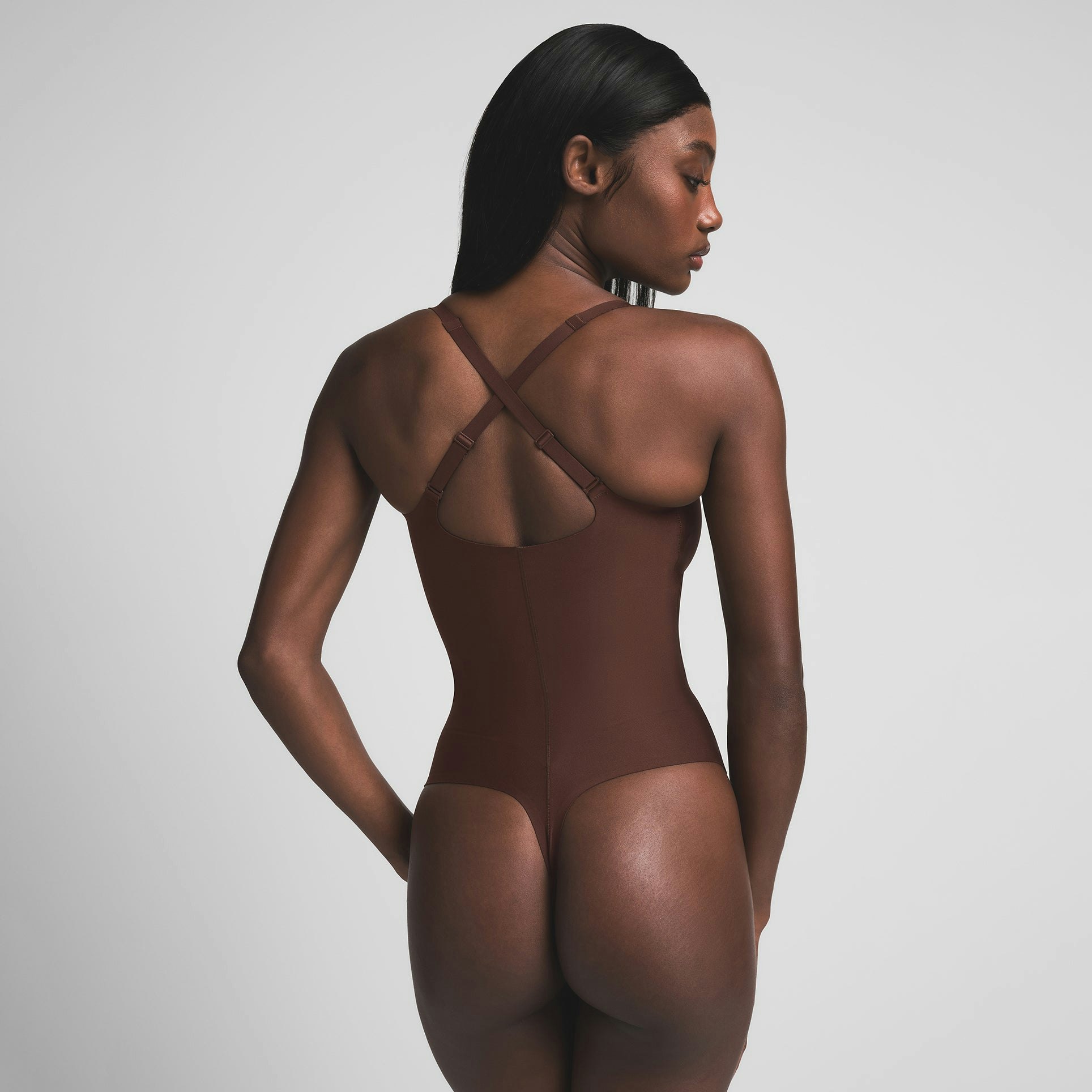SKIMS BODY CORE SCULPT PLUNGE THONG BODYSUIT | COCOA ON A MODEL BACK VIEW | FOCUS: 0.0, 1.0, 0.9