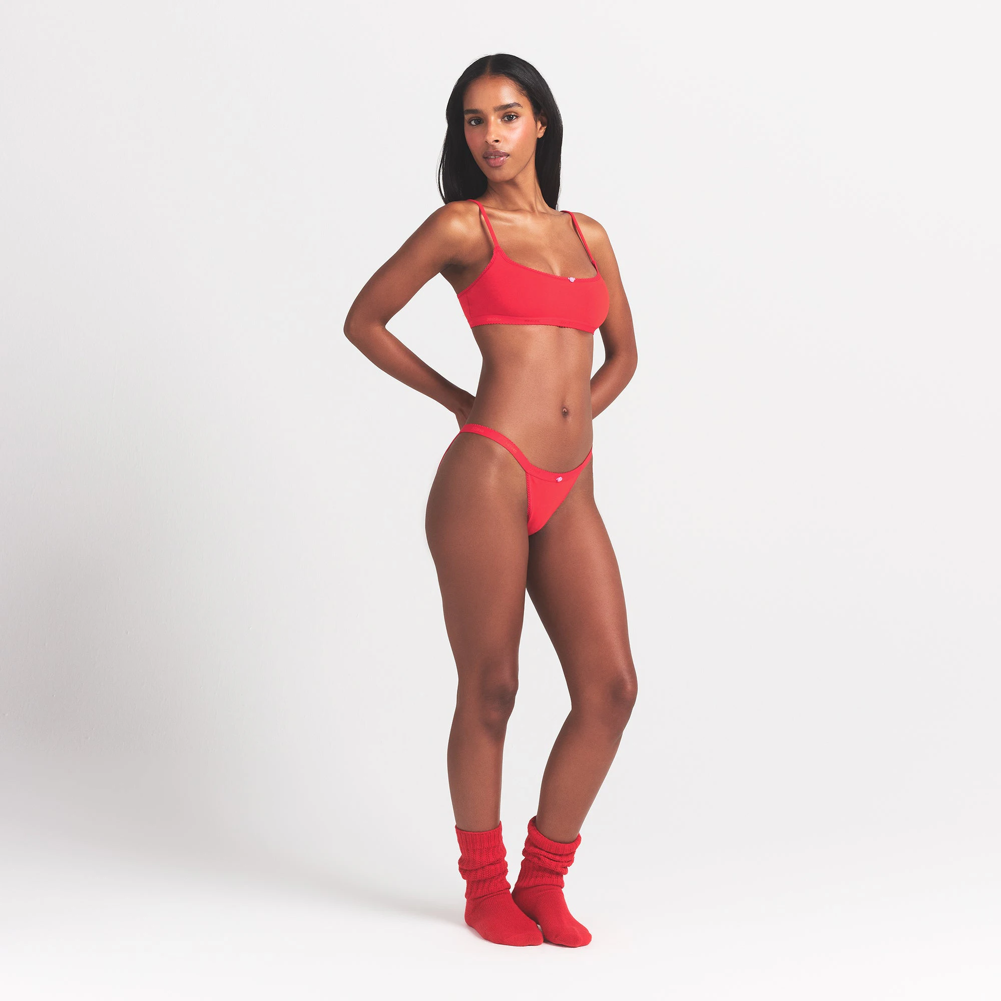 LIGHTWEIGHT COTTON LOGO PICOT STRING BIKINI | RUBY TONAL ON A MODEL SIDE VIEW @ | FOCUS: 0.0, 1.0, 0.9