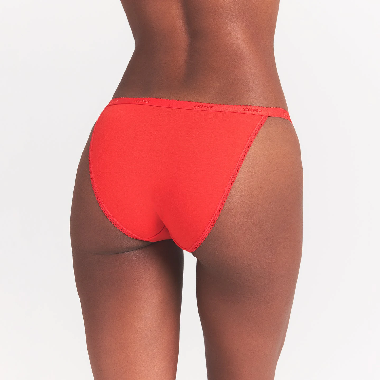 LIGHTWEIGHT COTTON LOGO PICOT STRING BIKINI | RUBY TONAL ON A MODEL BACK VIEW @ | FOCUS: 0.0, 1.0, 0.9