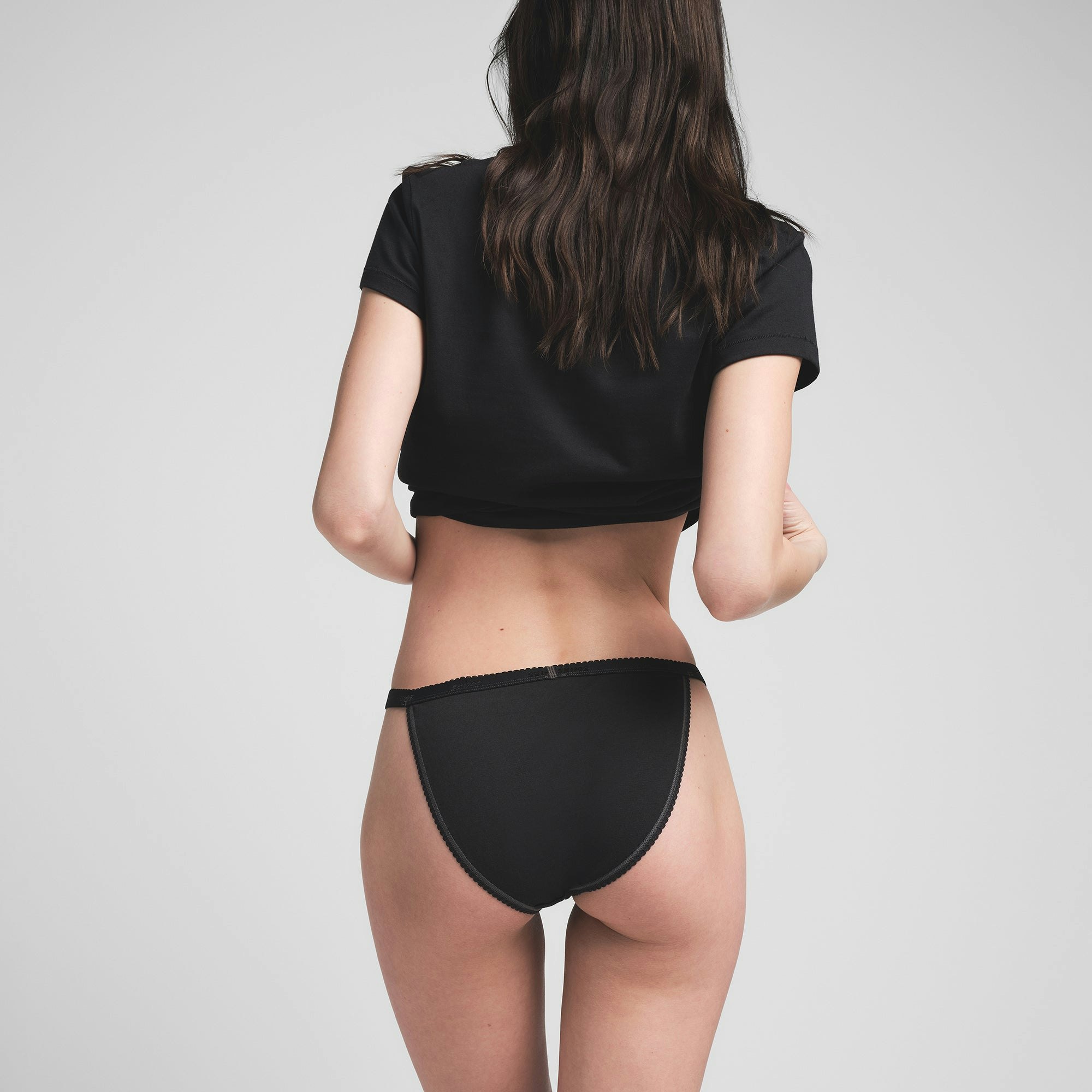 LIGHTWEIGHT COTTON PICOT LOGO STRING BIKINI | SOOT ON A MODEL BACK VIEW @ | FOCUS: 0.0, 1.0, 0.9