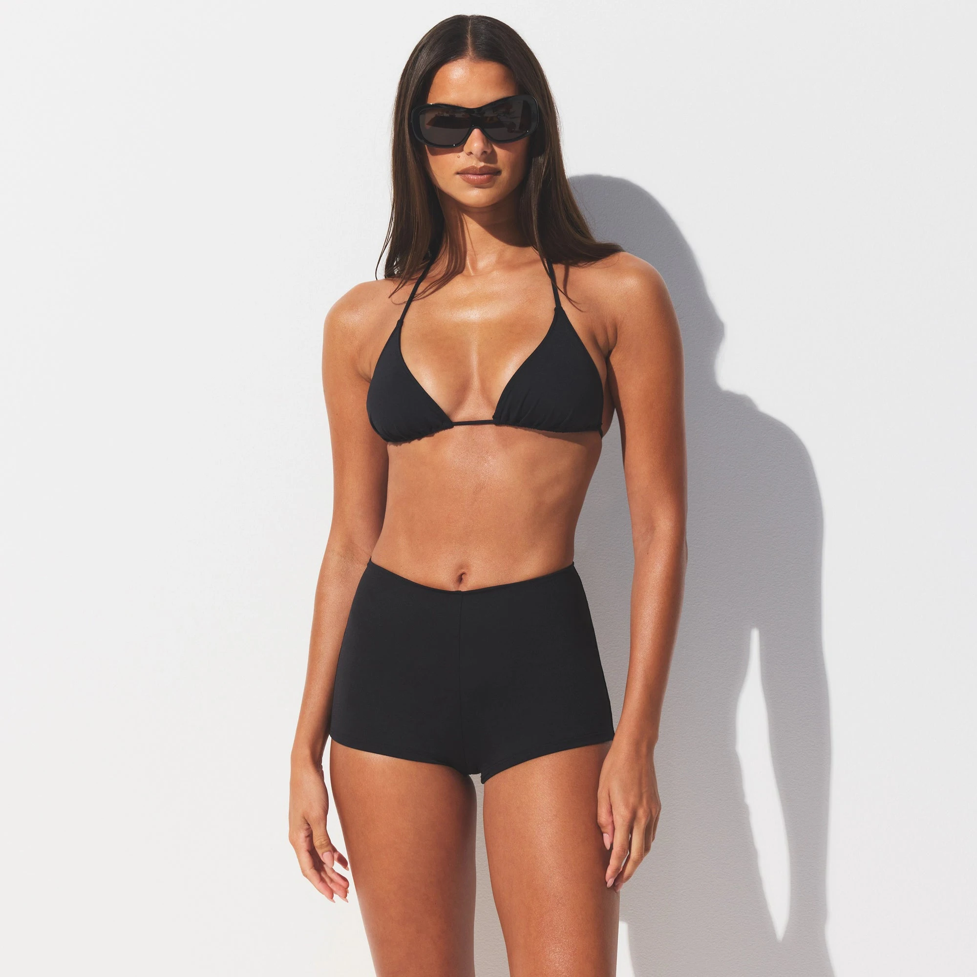 SIGNATURE SWIM SHORT BIKINI BOTTOM | ONYX ON A MODEL SIDE VIEW @ | FOCUS: 0.0, 1.0, 0.9