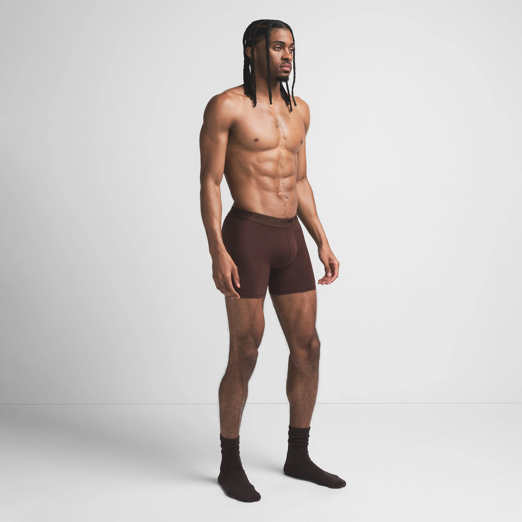 SKIMS STRETCH MENS 5" BOXER BRIEF | COCOA ON A MODEL SIDE VIEW @ | FOCUS: 0.9, 0.1, 0.7