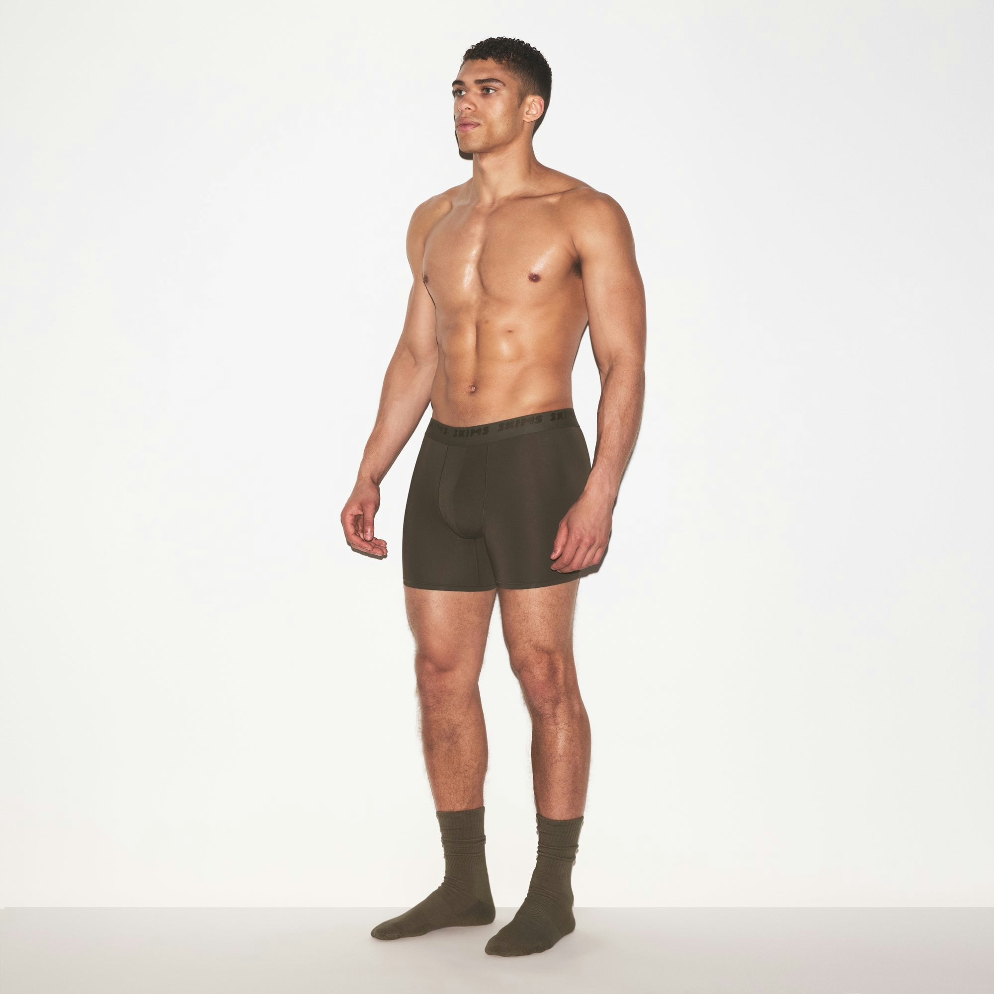 SKIMS STRETCH MENS 5 INCH BOXER BRIEF | LODEN ON A MODEL FRONT VIEW @ | FOCUS: 0.0, 1.0, 0.9
