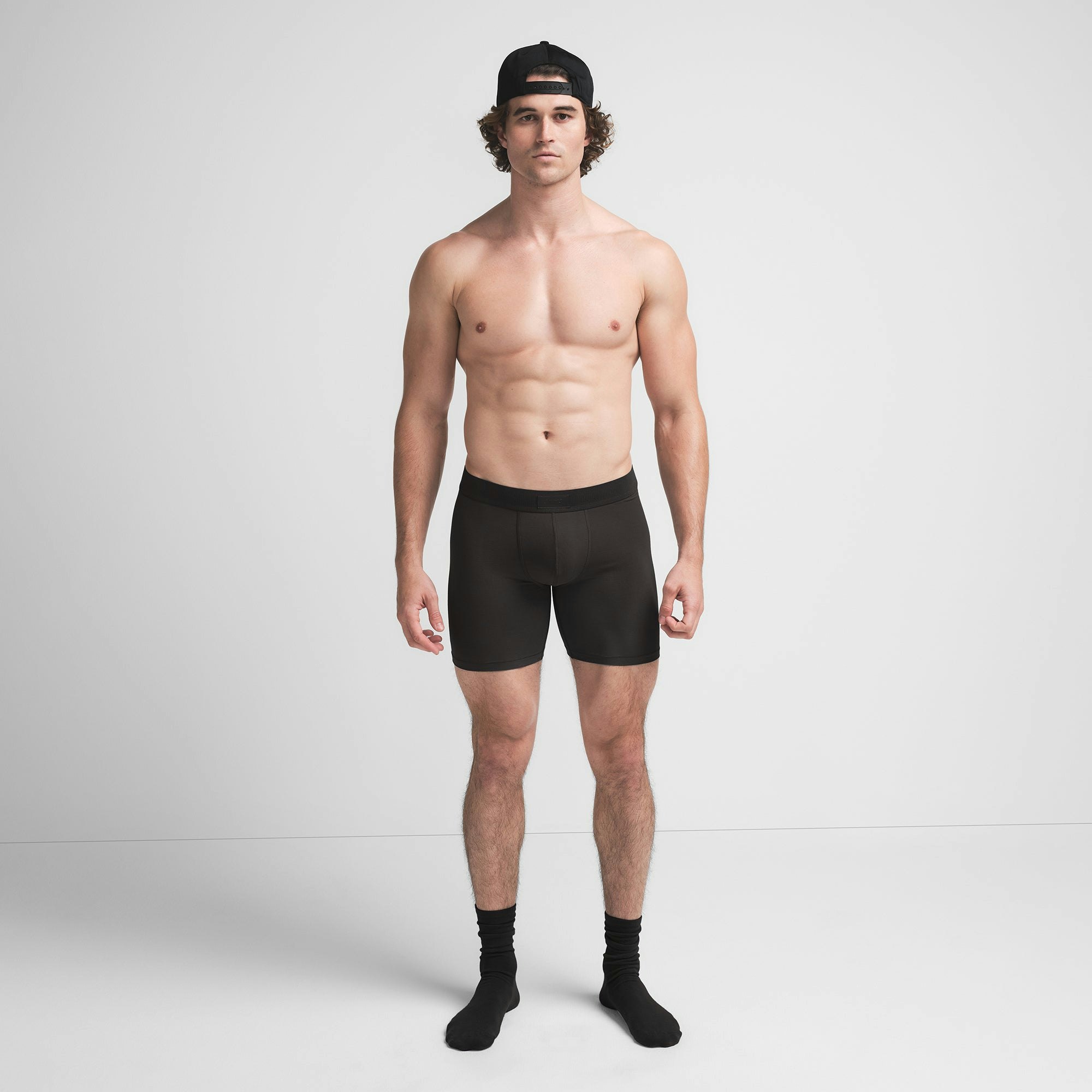 SKIMS COTTON MENS 5" BOXER BRIEF | ONYX ON A MODEL FRONT VIEW @ | FOCUS: 0.9, 0.1, 0.7
