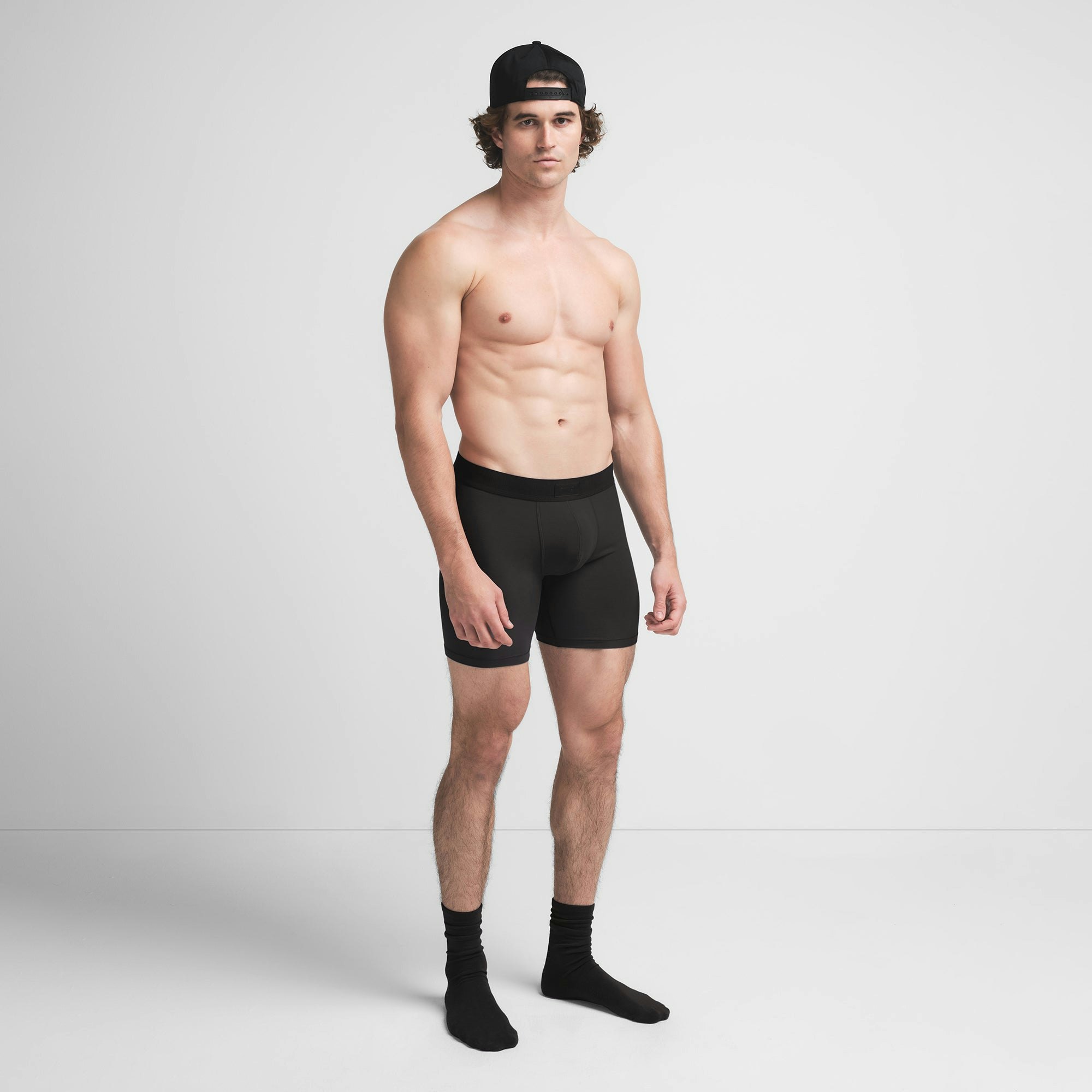 SKIMS COTTON MENS 5" BOXER BRIEF | ONYX ON A MODEL SIDE VIEW @ | FOCUS: 0.9, 0.1, 0.7