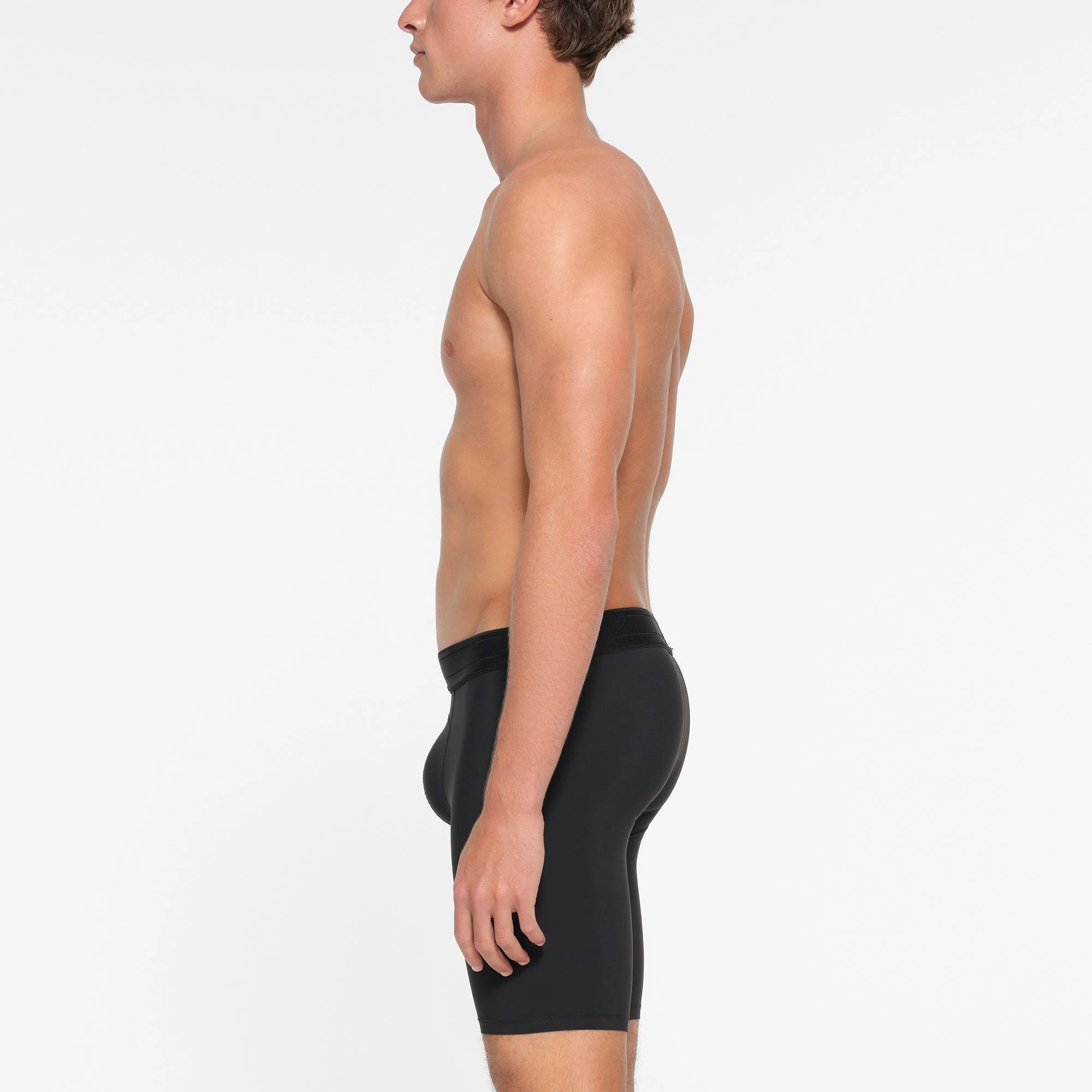 SKIMS SPORT MENS 9" BOXER BRIEF | OBSIDIAN ON A MODEL SIDE VIEW