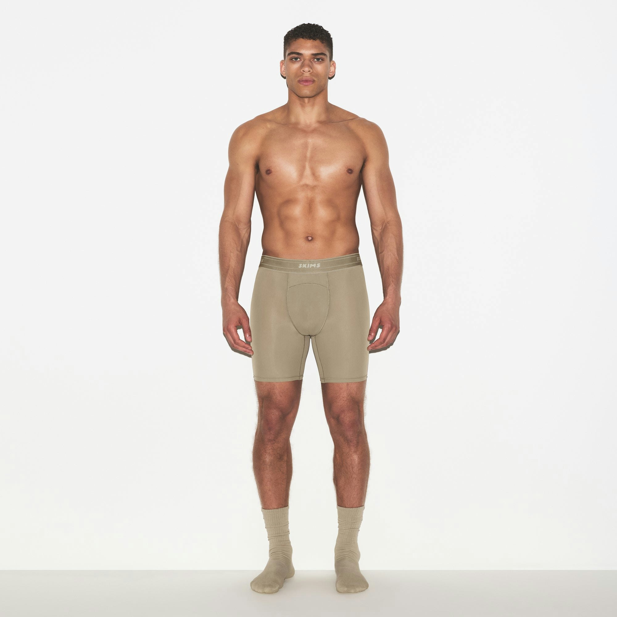 SKIMS SPORT MENS 7 INCH BOXER BRIEF | DUNE ON A MODEL FRONT VIEW | FOCUS: 0.0, 1.0, 0.9