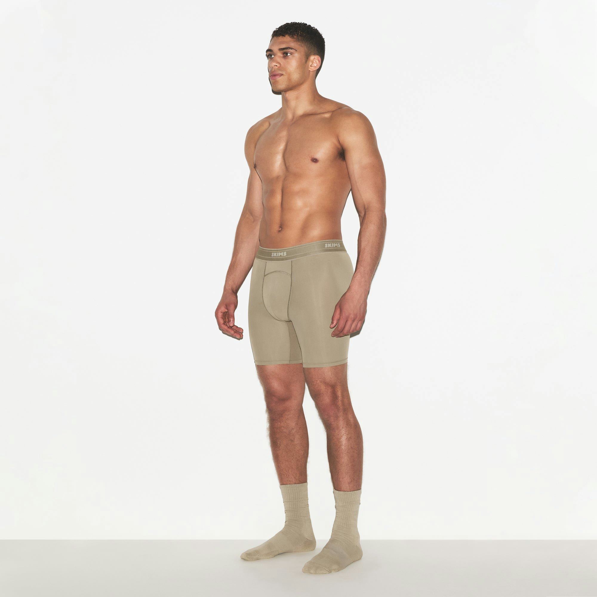 SKIMS SPORT MENS 7 INCH BOXER BRIEF | DUNE ON A MODEL FRONT VIEW | FOCUS: 0.0, 1.0, 0.9