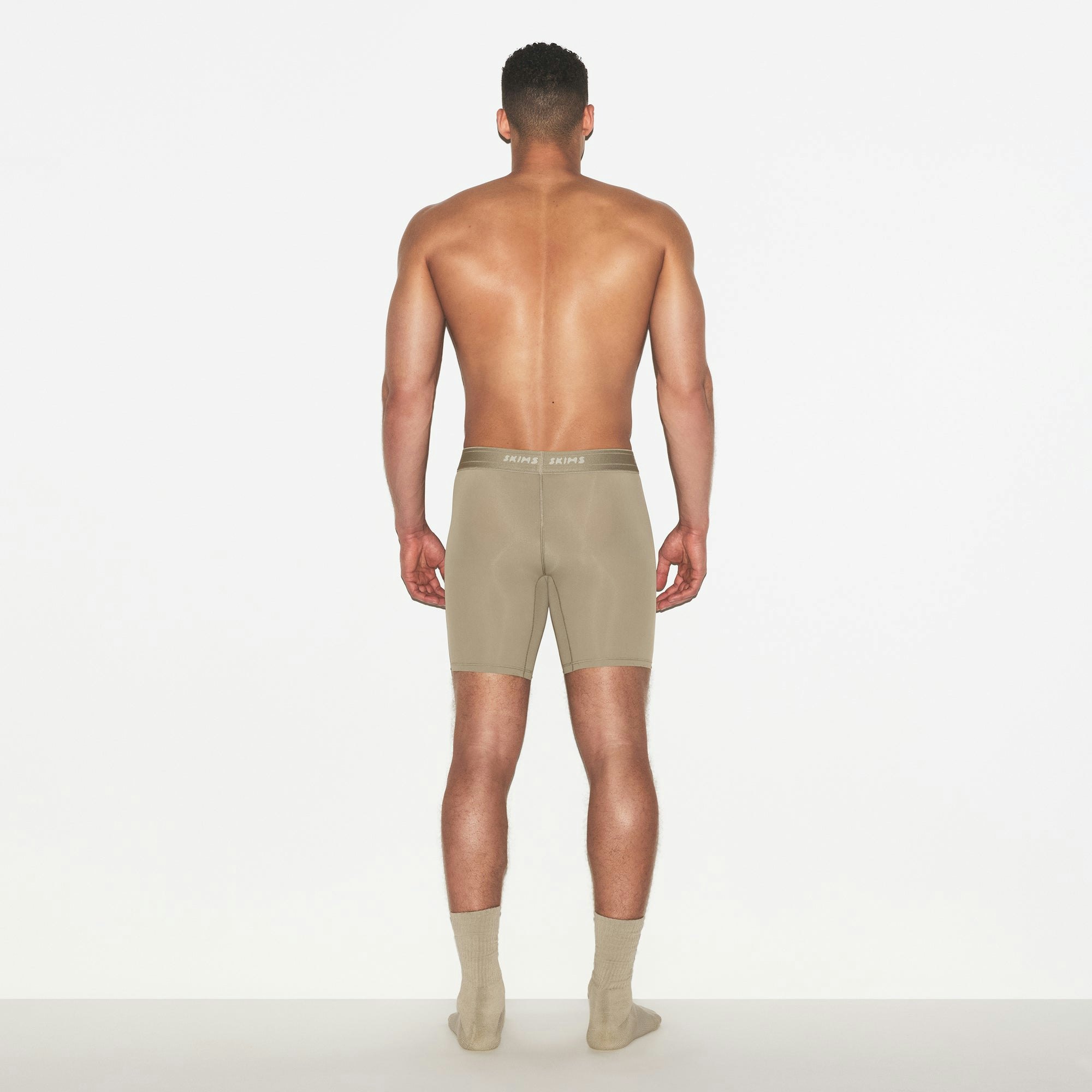 SKIMS SPORT MENS 7 INCH BOXER BRIEF | DUNE ON A MODEL FRONT VIEW | FOCUS: 0.0, 1.0, 0.9