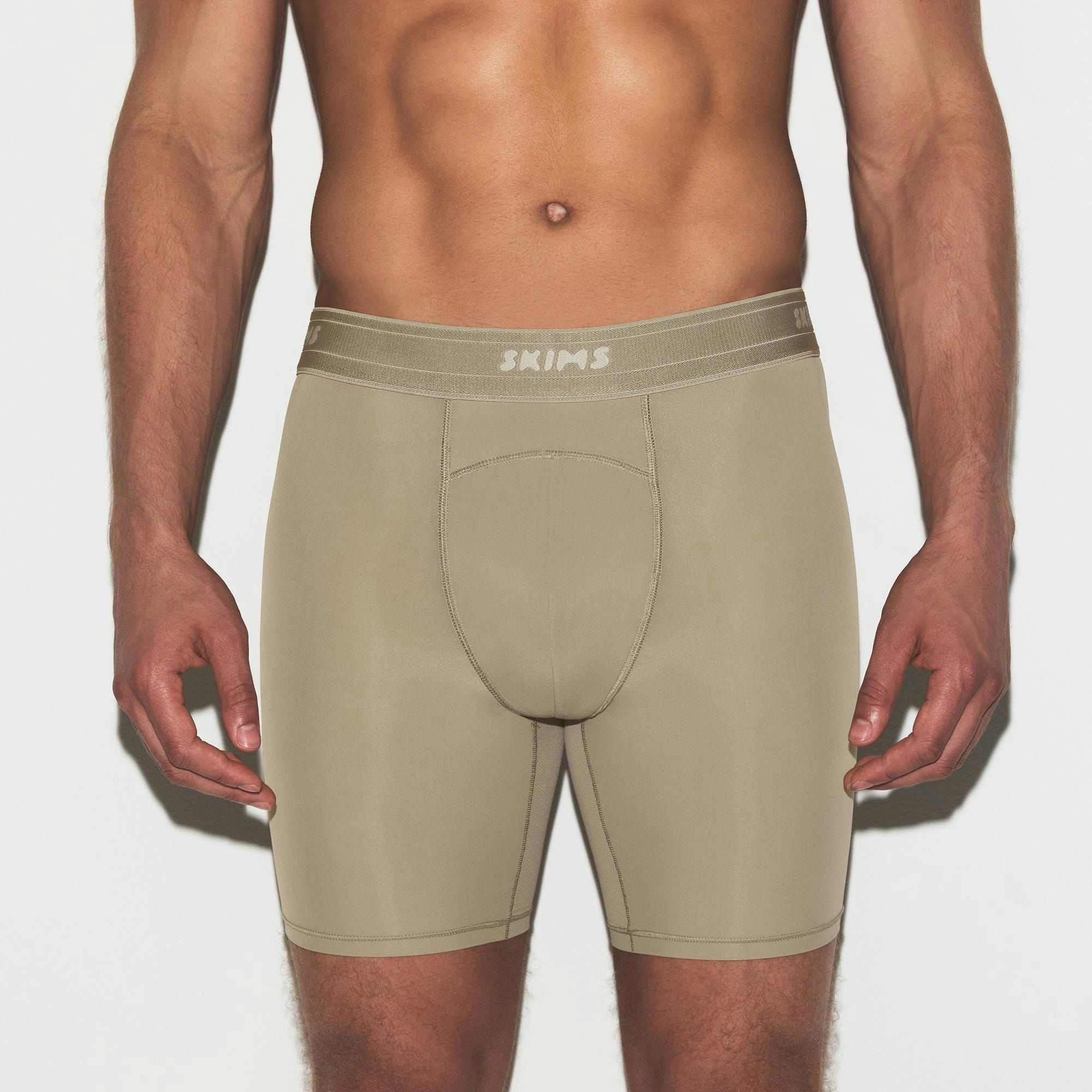 SKIMS SPORT MENS 7" BOXER BRIEF | DUNE ON A MODEL SIDE VIEW | FOCUS: 0.0, 1.0, 0.9