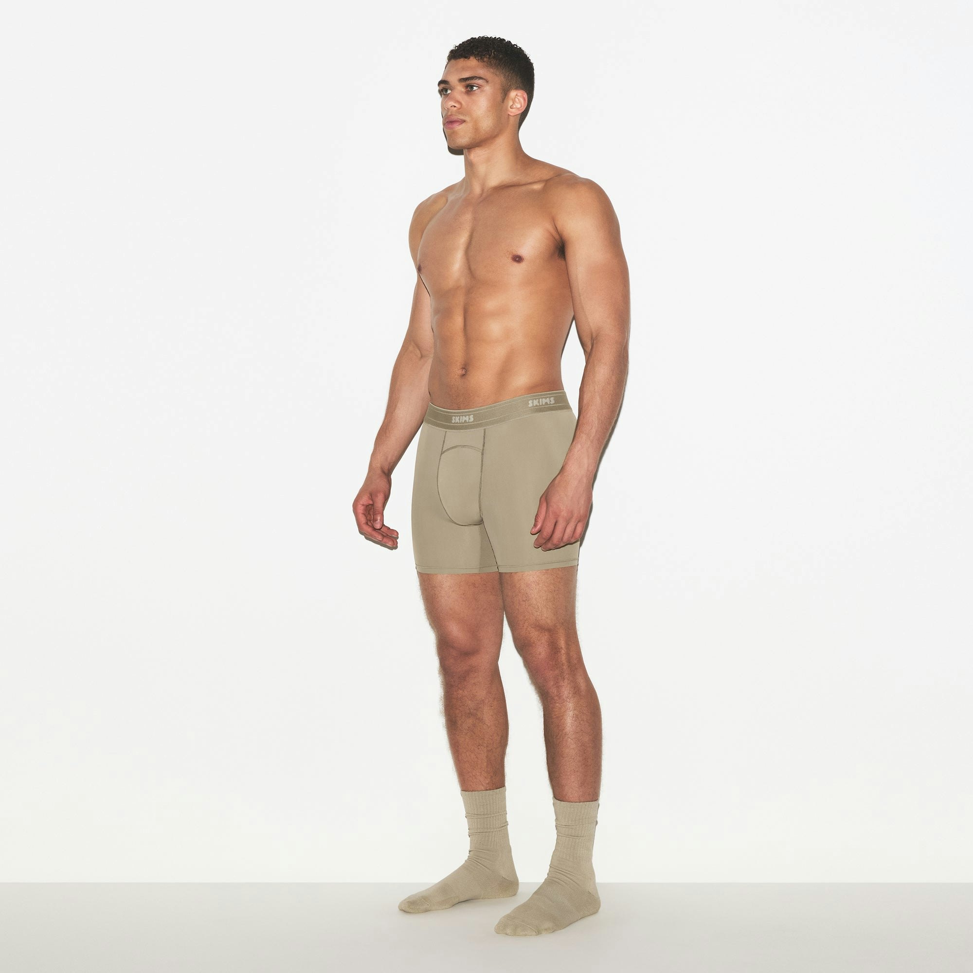 SKIMS SPORT MENS 5 INCH BOXER BRIEF | DUNE ON A MODEL FRONT VIEW | FOCUS: 0.0, 1.0, 0.9