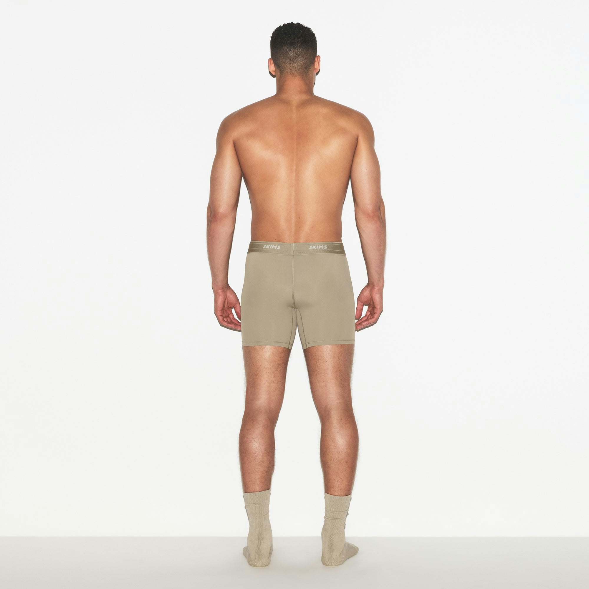 SKIMS SPORT MENS 5 INCH BOXER BRIEF | DUNE ON A MODEL FRONT VIEW | FOCUS: 0.0, 1.0, 0.9