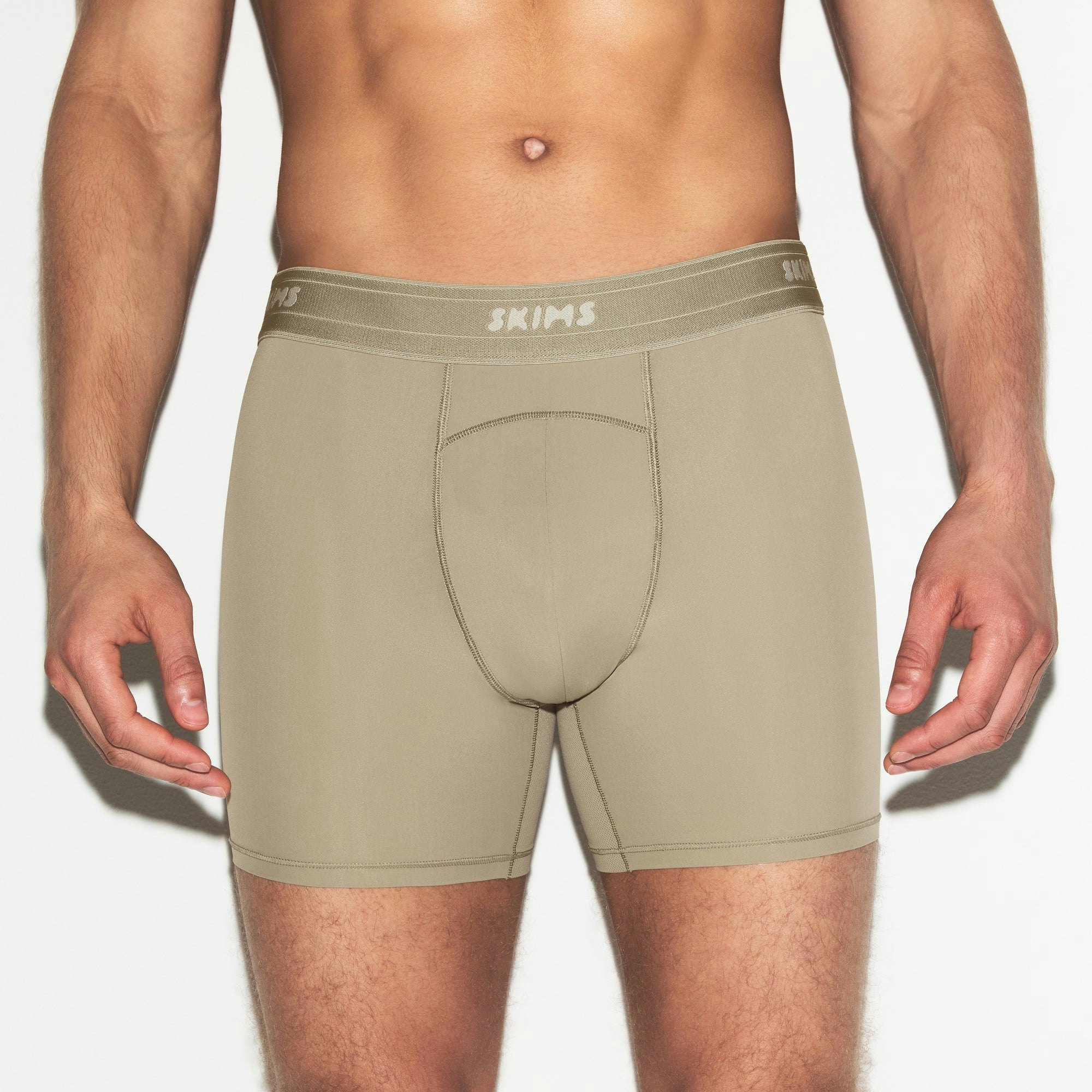 SKIMS SPORT MENS 5 INCH BOXER BRIEF | DUNE ON A MODEL SIDE VIEW | FOCUS: 0.0, 1.0, 0.9