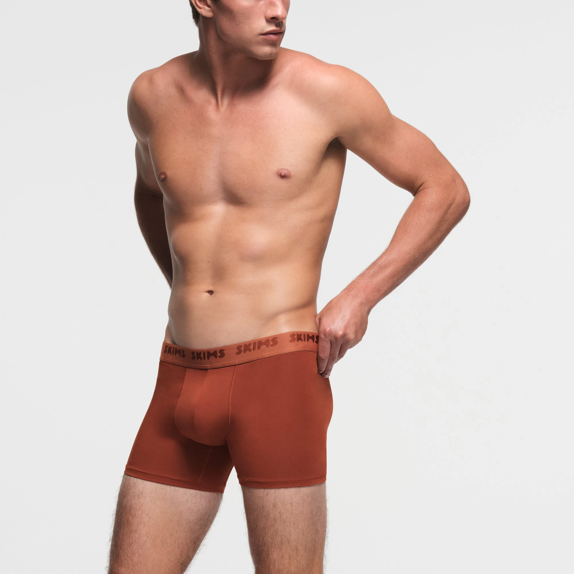 SKIMS STRETCH MENS 3" BOXER BRIEF | RUST ON A MODEL SIDE VIEW
