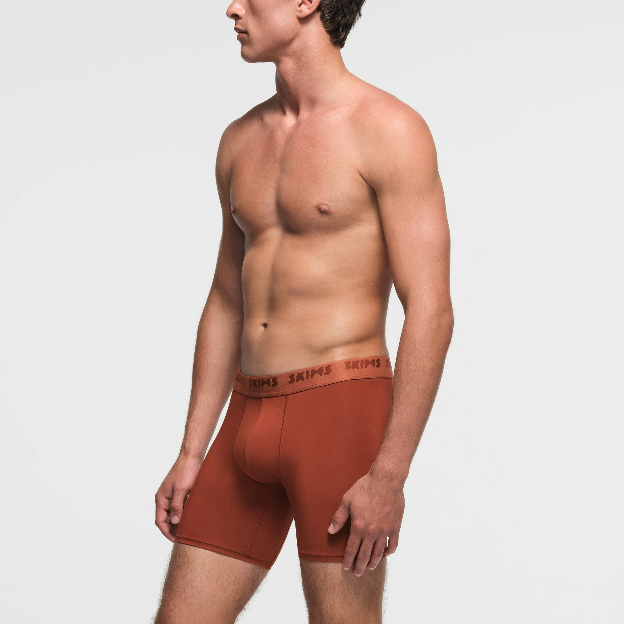 SKIMS STRETCH MENS 5" BOXER BRIEF | RUST ON A MODEL SIDE VIEW