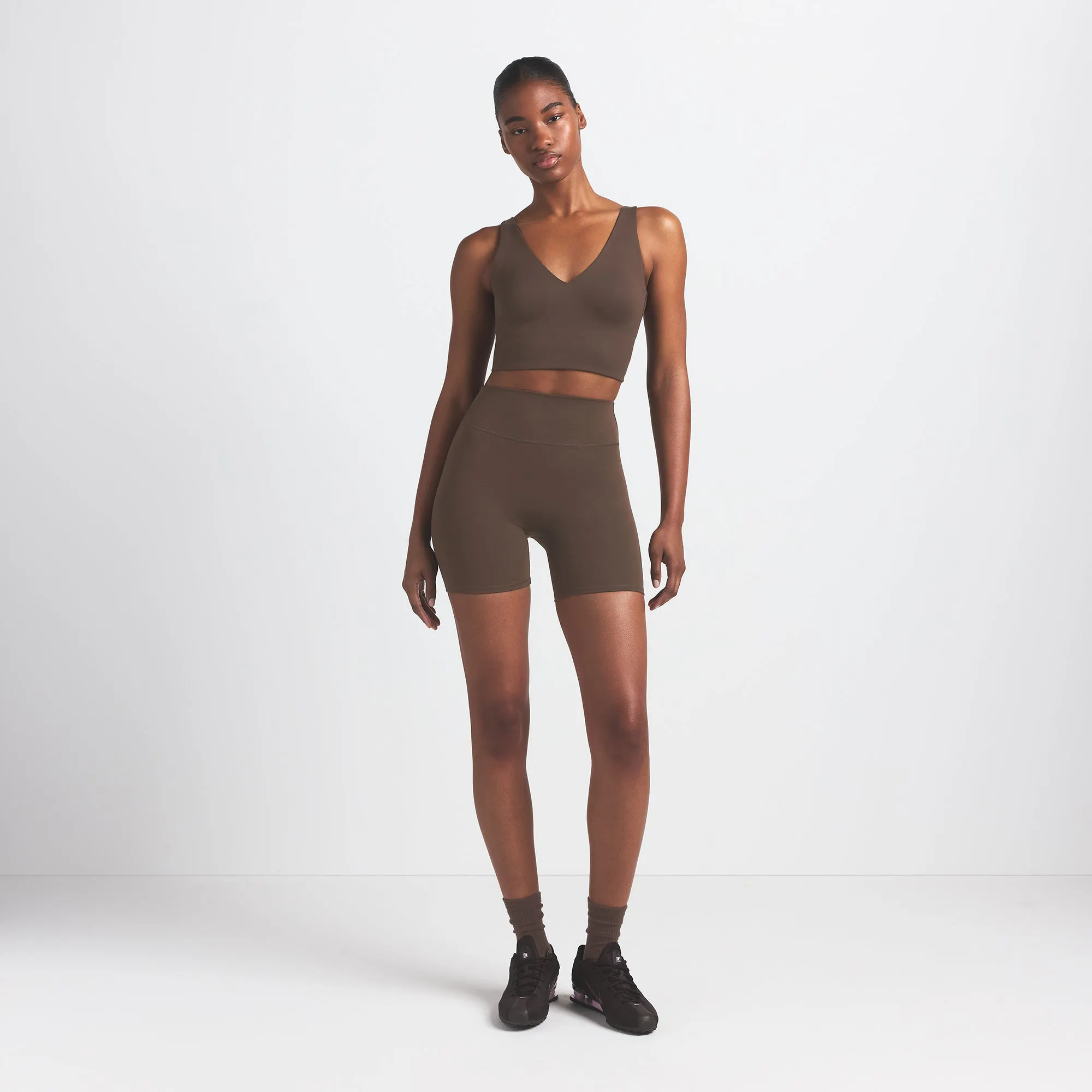 NikeSKIMS MATTE 5" BIKER SHORT | DARK SEPIA ON A MODEL FRONT VIEW @ | FOCUS: 0.9, 0.1, 0.7