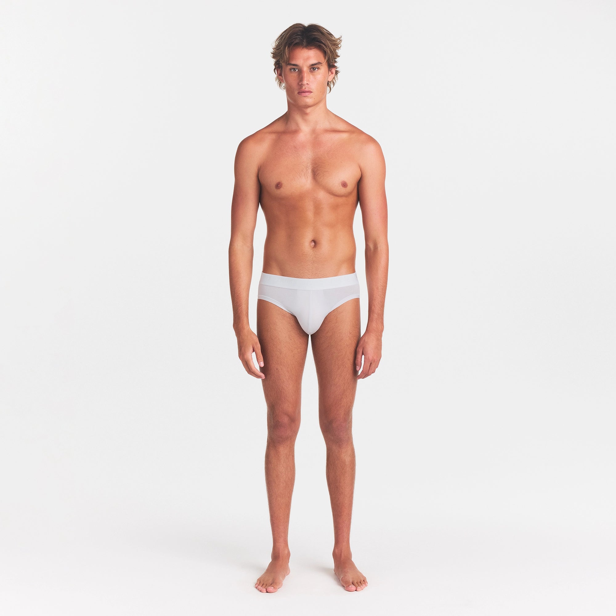 SKIMS STRETCH MENS BRIEF | CHALK ON A MODEL FRONT VIEW
