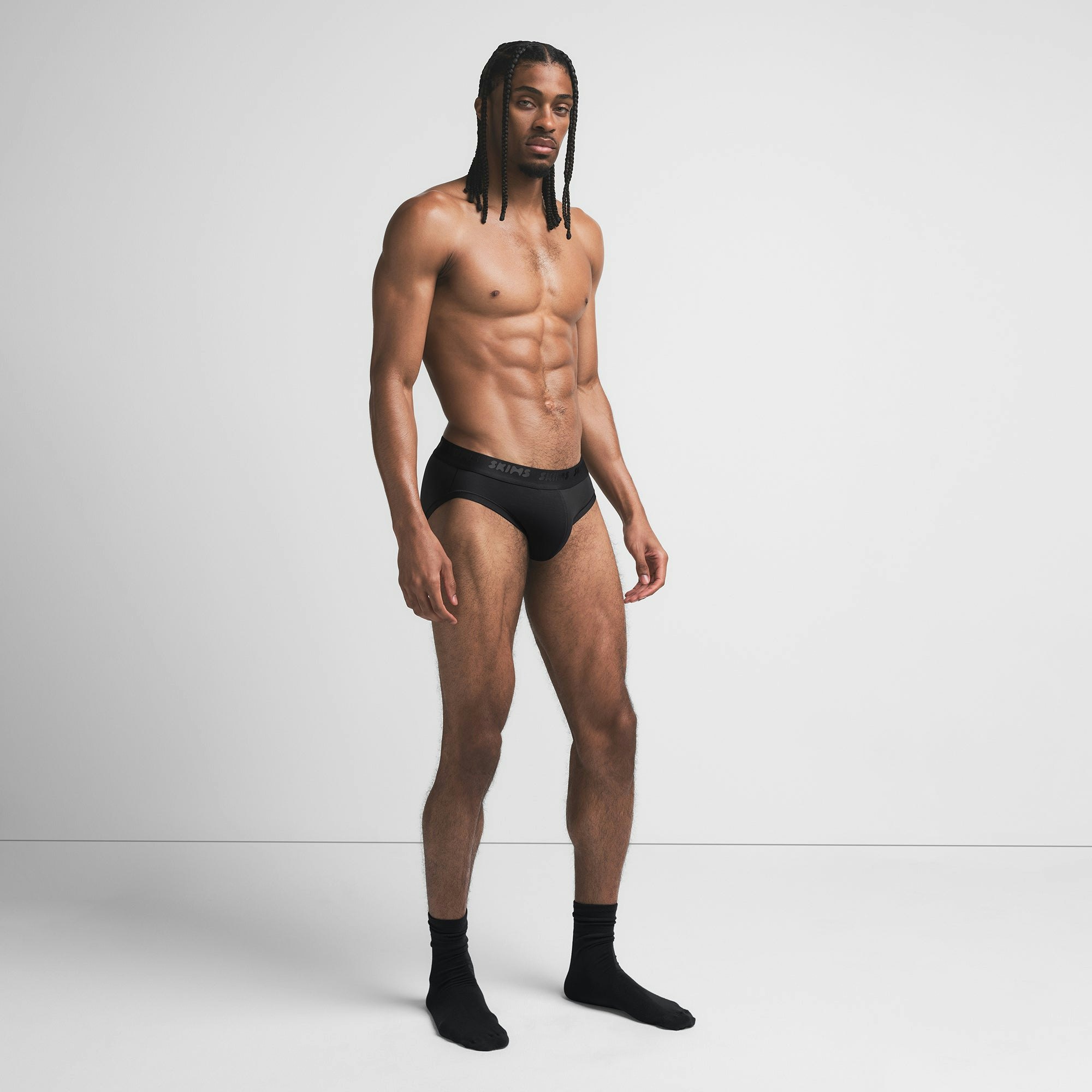 SKIMS STRETCH MENS BRIEF | OBSIDIAN ON A MODEL SIDE VIEW @ | FOCUS: 0.9, 0.1, 0.7