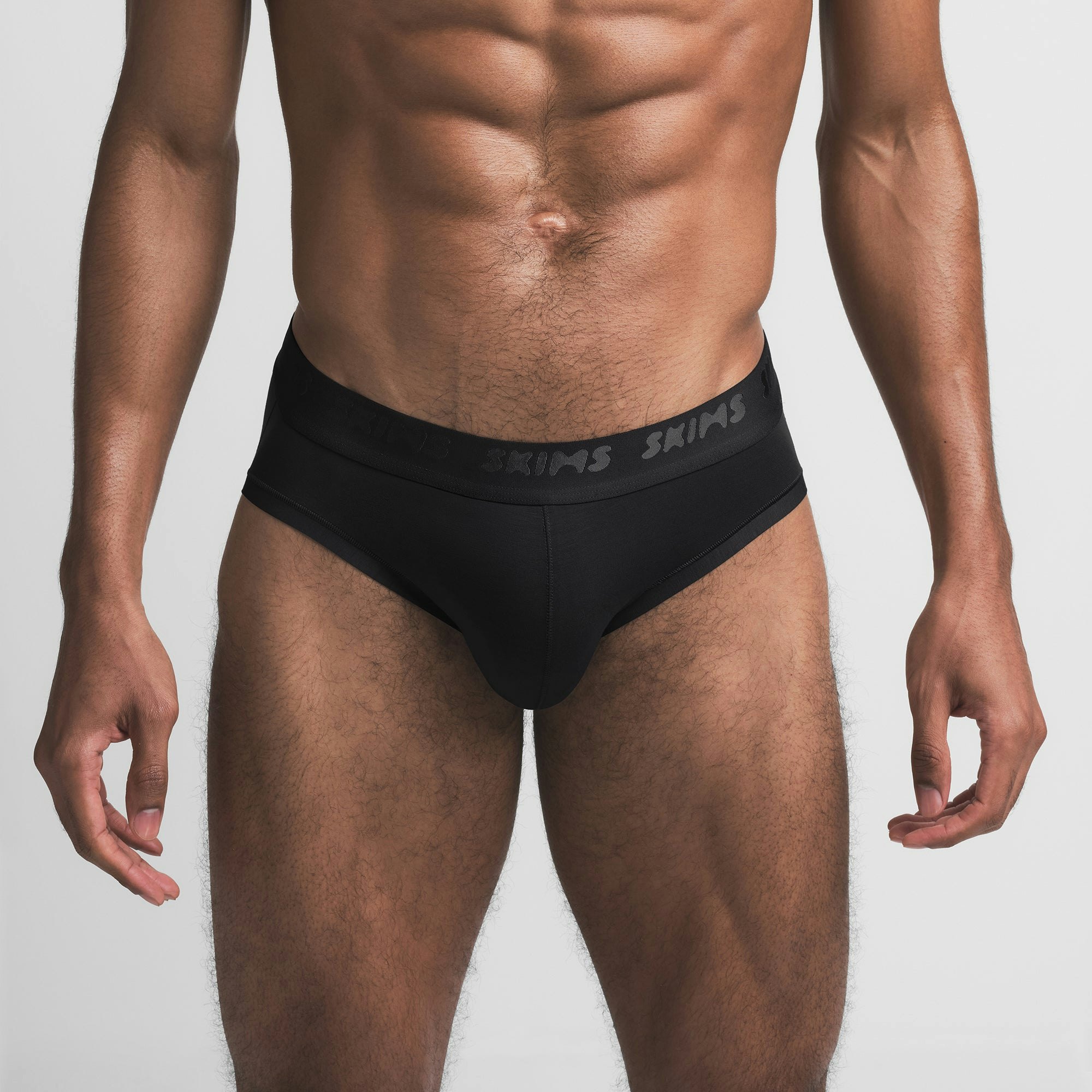 SKIMS STRETCH MENS BRIEF | OBSIDIAN ON A MODEL FRONT VIEW @ | FOCUS: 0.9, 0.1, 0.7