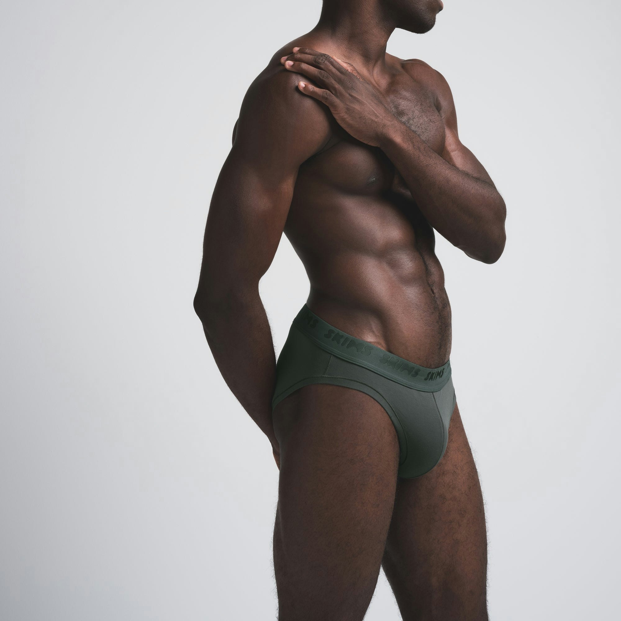 SKIMS STRETCH MENS BRIEF | DEEP SEA ON A MODEL SIDE VIEW