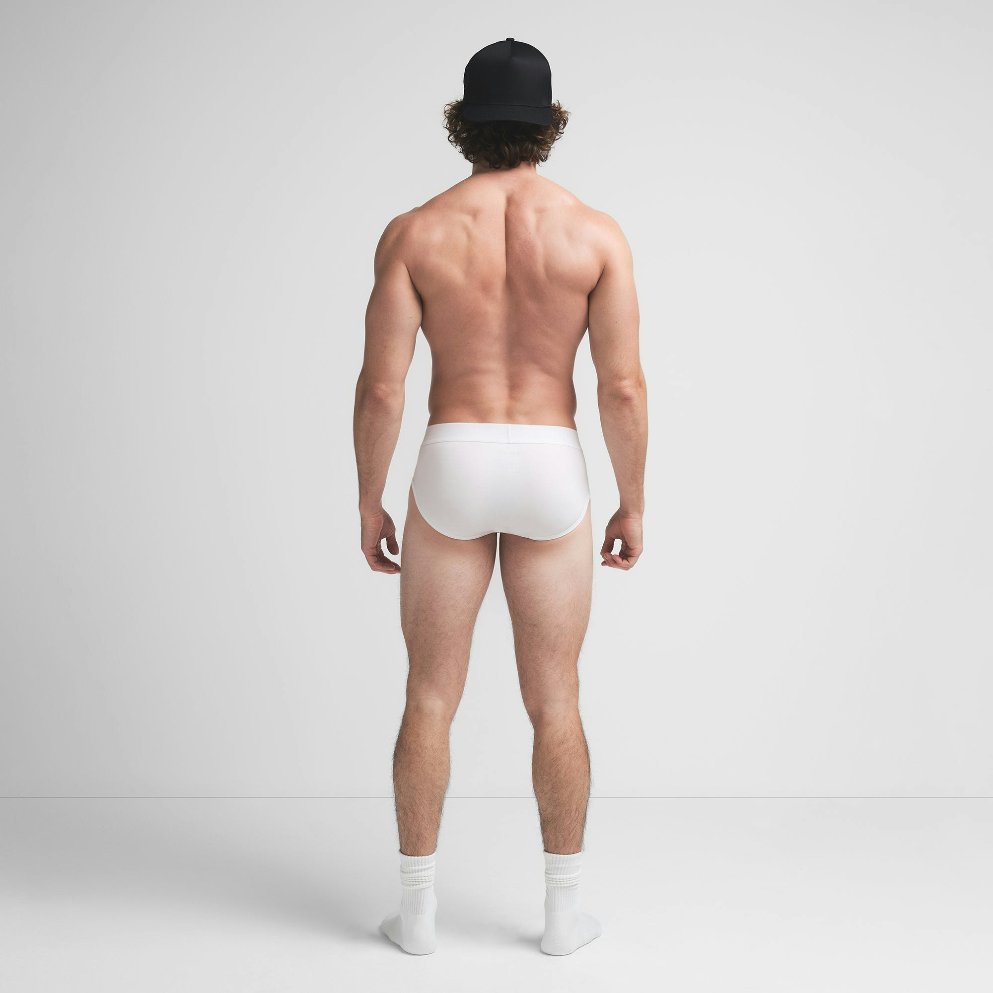 SKIMS COTTON MENS BRIEF | CHALK ON A MODEL BACK VIEW @ | FOCUS: 0.9, 0.1, 0.7