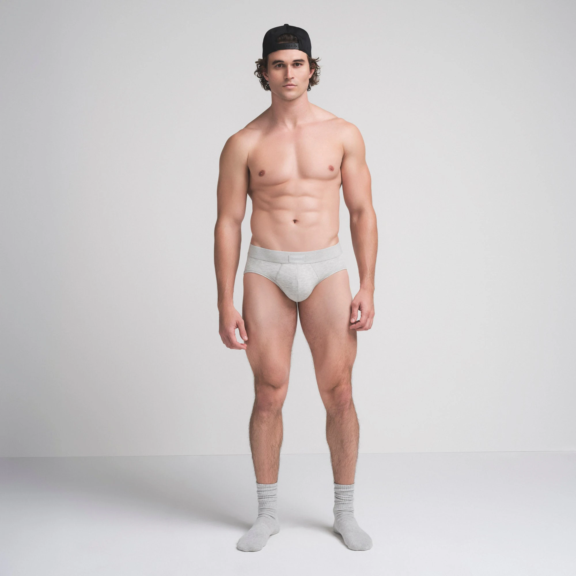 SKIMS COTTON MENS BRIEF | LIGHT HEATHER GREY ON A MODEL FRONT VIEW @ | FOCUS: 0.9, 0.1, 0.7