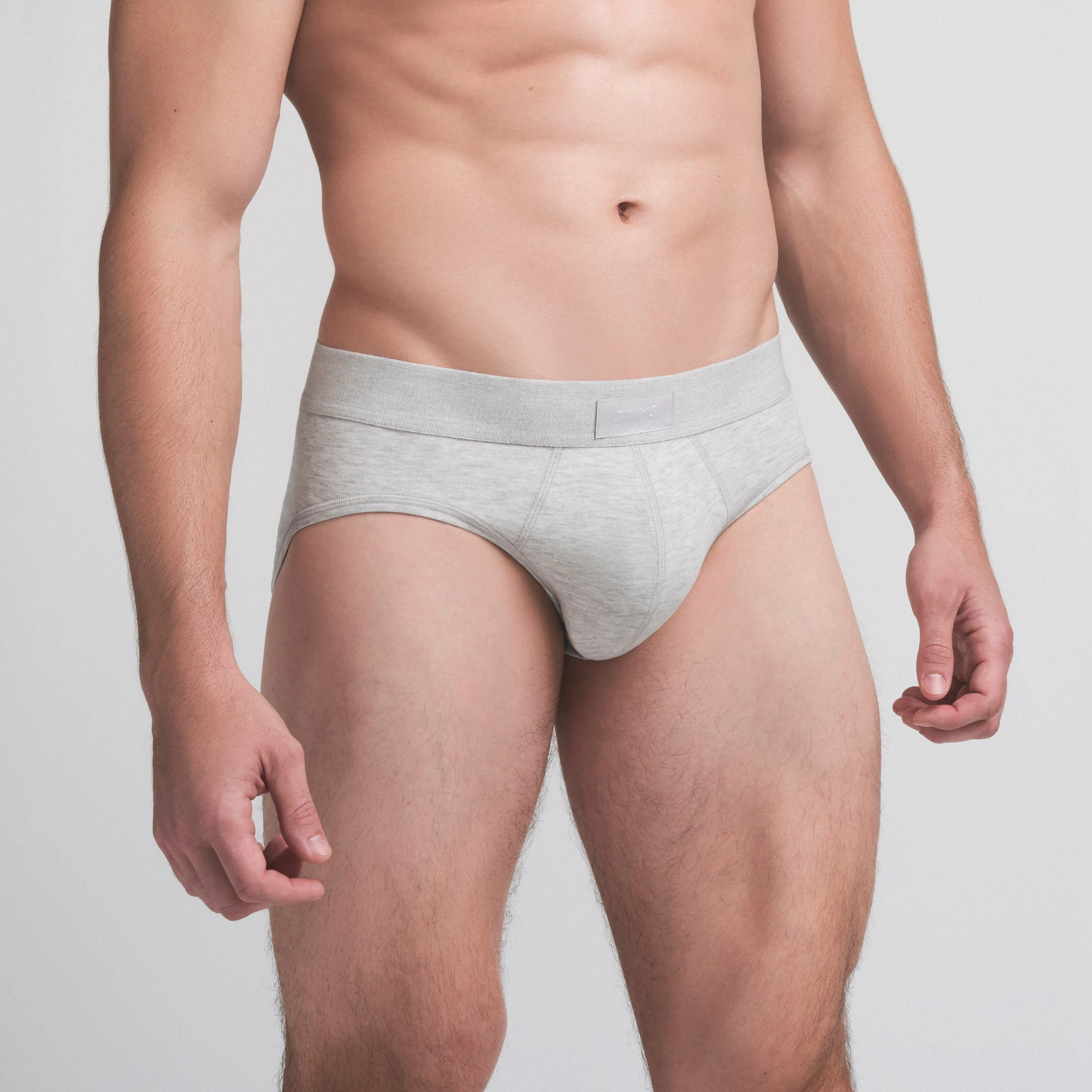 SKIMS COTTON MENS BRIEF | LIGHT HEATHER GREY ON A MODEL SIDE VIEW @ | FOCUS: 0.9, 0.1, 0.7