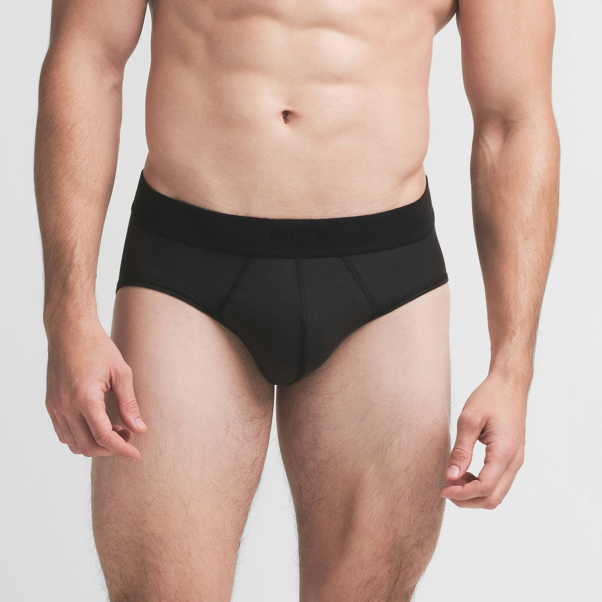 SKIMS COTTON MENS BRIEF | ONYX ON A MODEL FRONT VIEW @ | FOCUS: 0.9, 0.1, 0.7