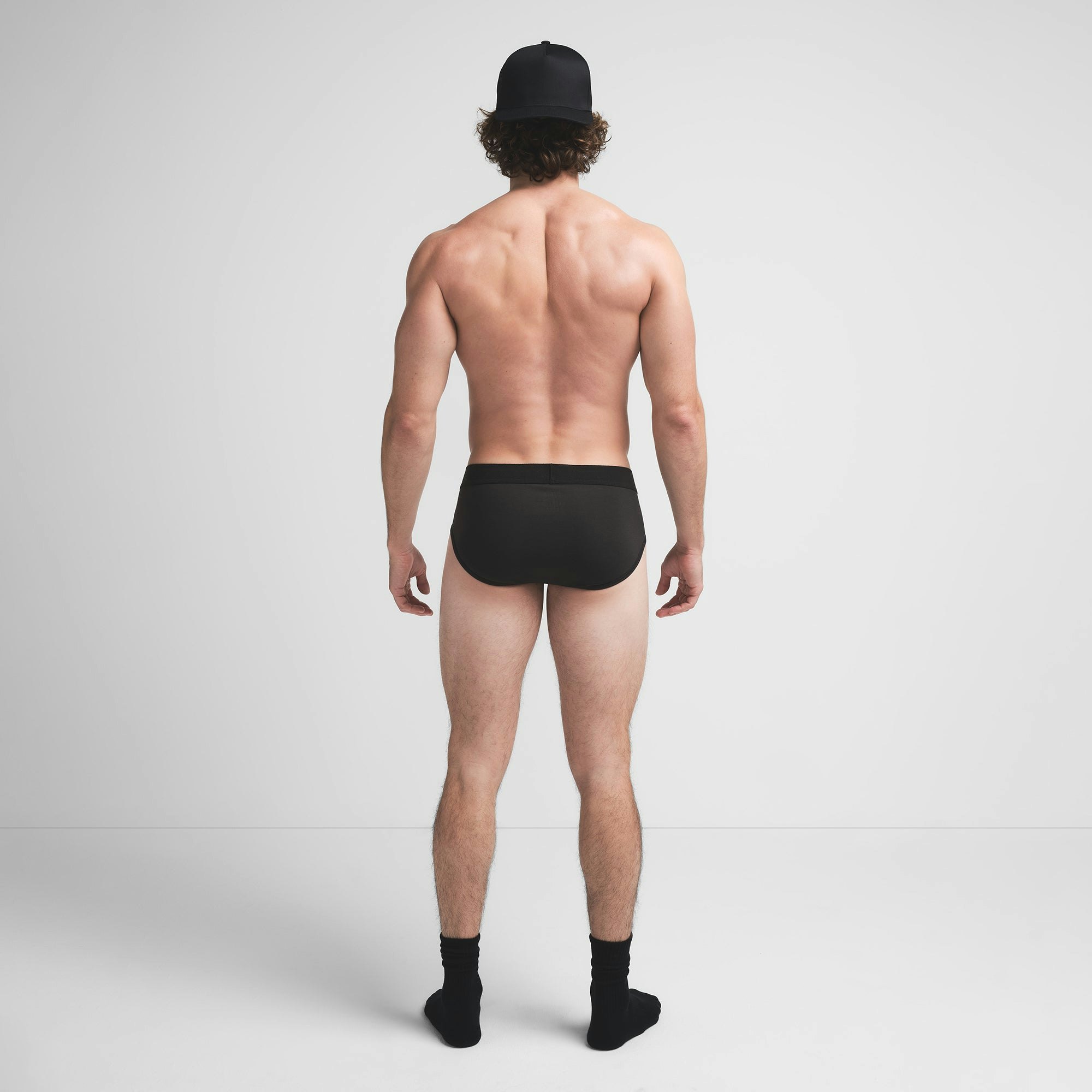 SKIMS COTTON MENS BRIEF | ONYX ON A MODEL BACK VIEW @ | FOCUS: 0.9, 0.1, 0.7