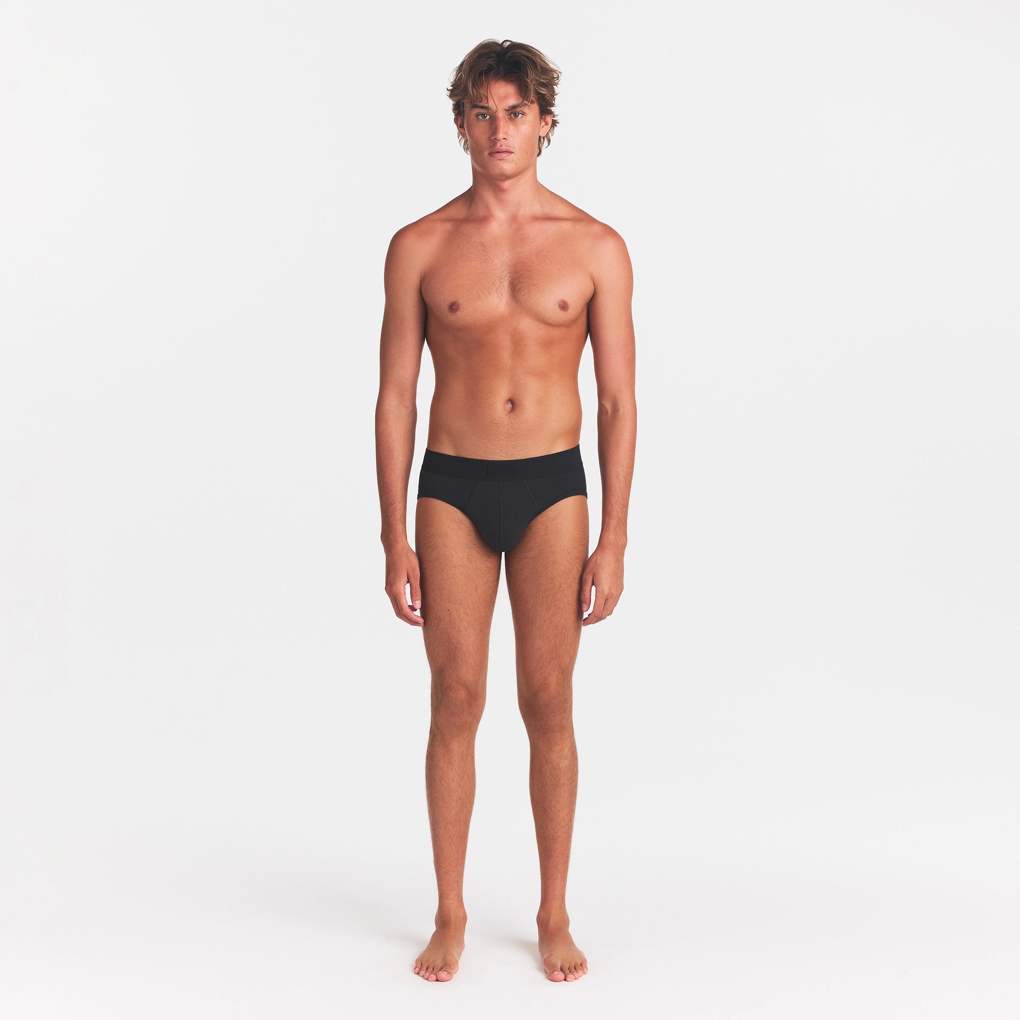 SKIMS COTTON MENS BRIEF | ONYX ON A MODEL FRONT VIEW