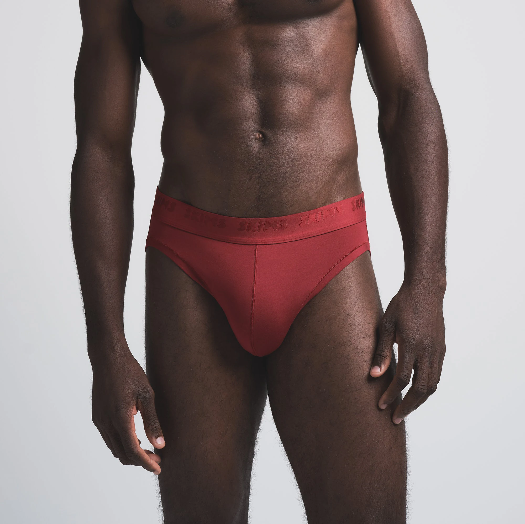 SKIMS STRETCH MENS BRIEF 3-PACK | BRICK MULTI ON A MODEL SIDE VIEW