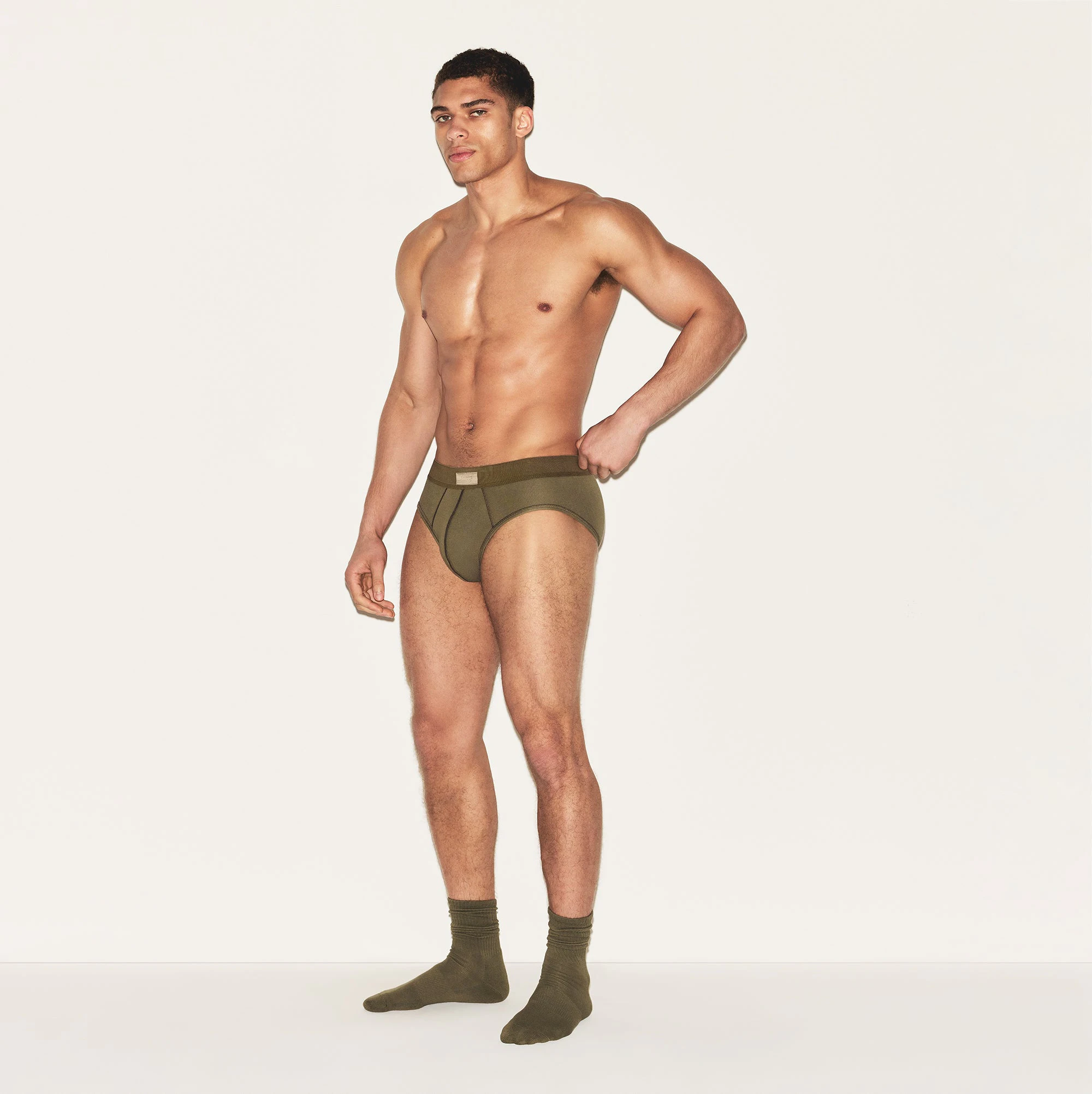 SKIMS COTTON MENS BRIEF 3-PACK | ARMY MULTI ON A MODEL SIDE VIEW | FOCUS: 0.0, 1.0, 0.9