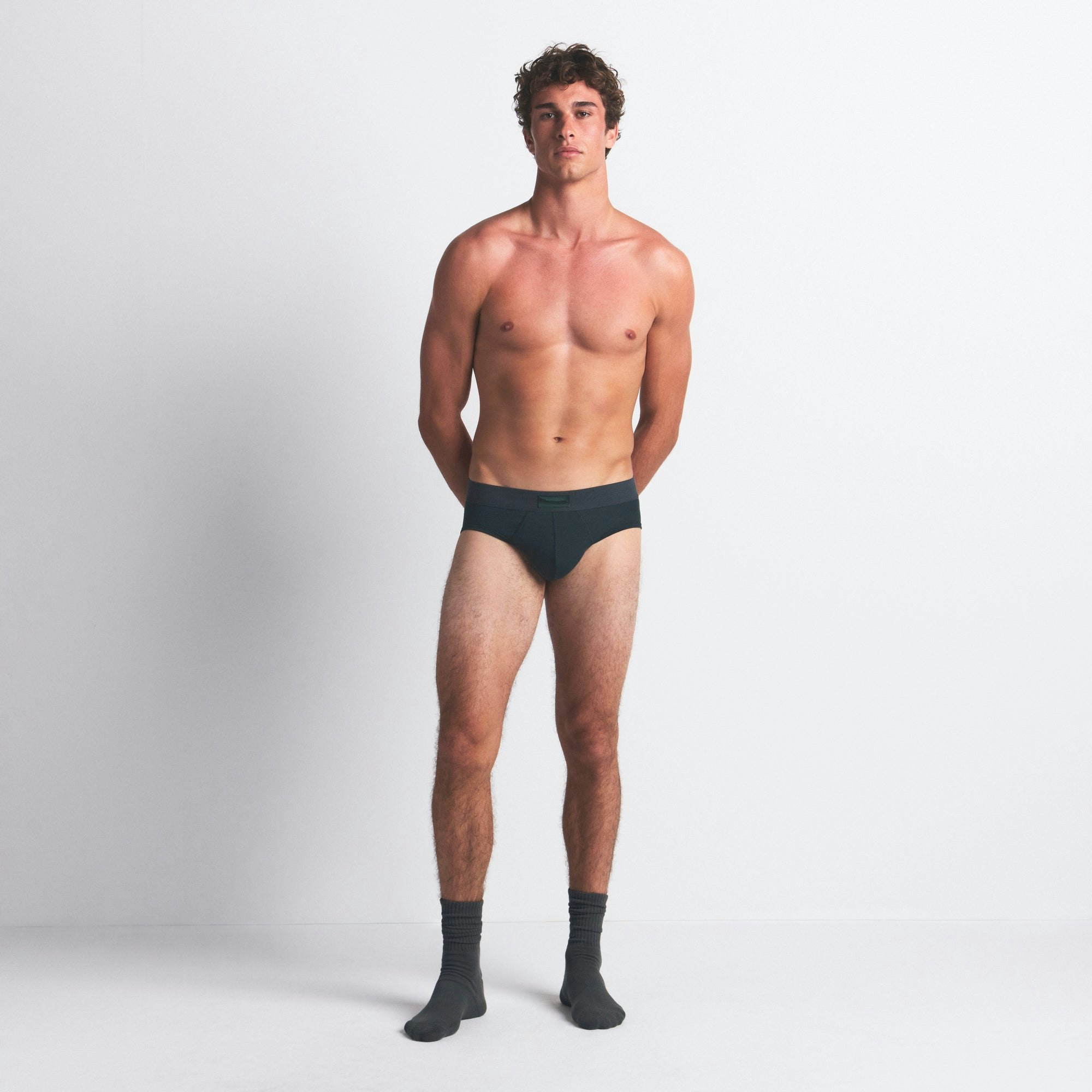 SKIMS COTTON MENS BRIEF 3-PACK | BLUE BLACK MULTI ON A MODEL FRONT VIEW @ | FOCUS: 0.0, 1.0, 0.9