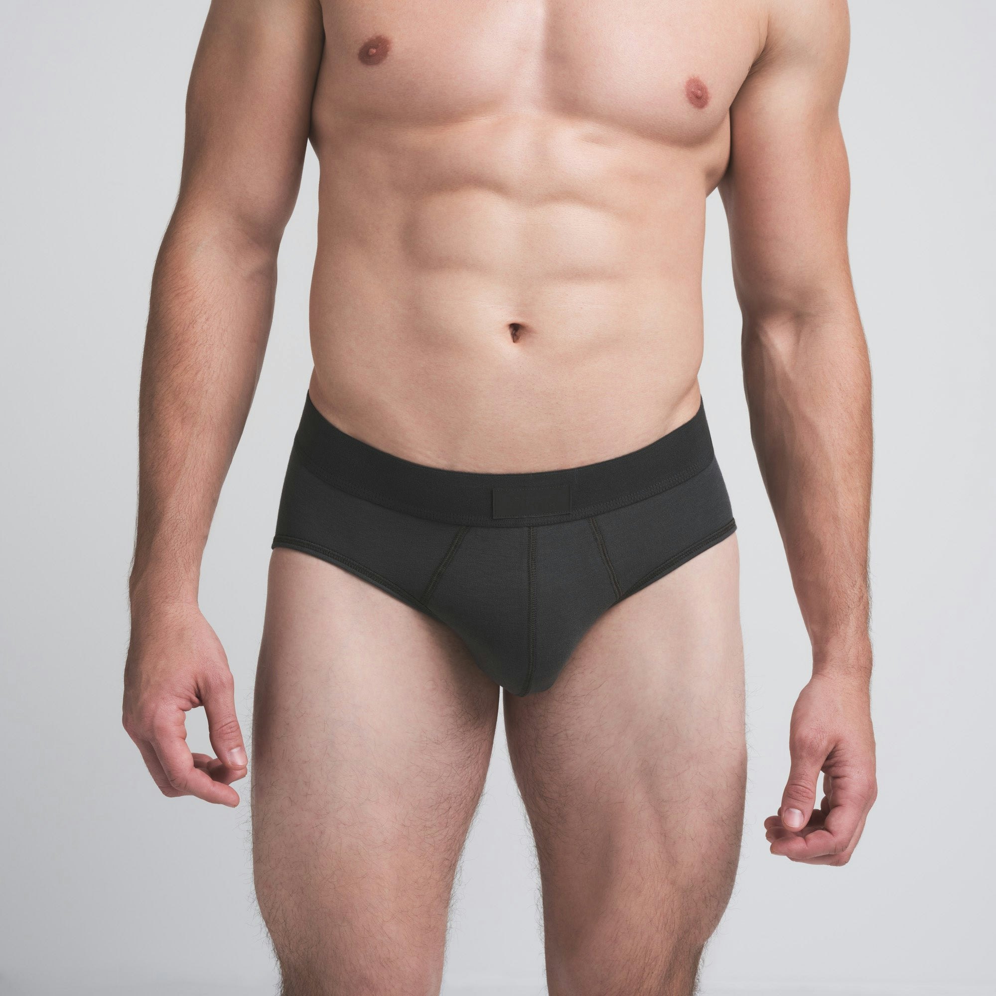 SKIMS COTTON MENS BRIEF 3-PACK | DARK SEPIA MULTI ON A MODEL FRONT VIEW | FOCUS: 0.0, 1.0, 0.9