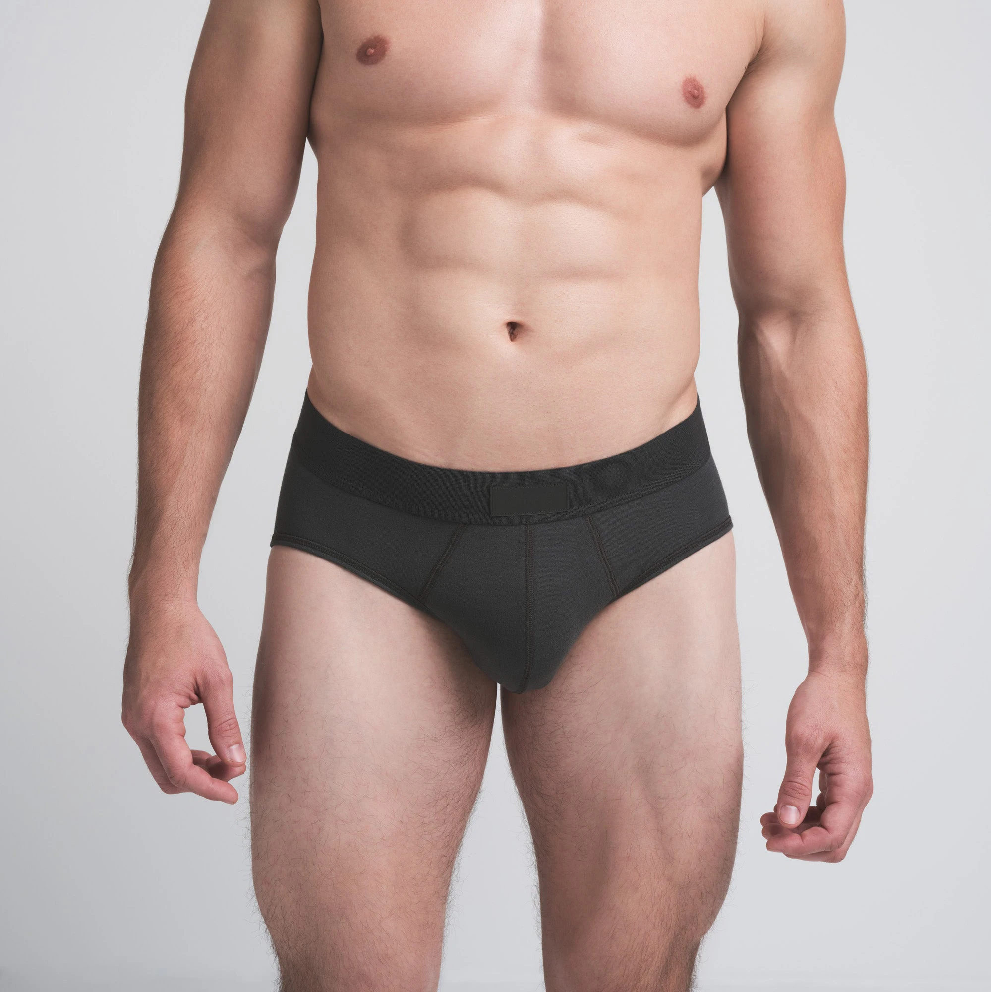 SKIMS COTTON MENS BRIEF 3-PACK | DARK SEPIA MULTI ON A MODEL FRONT VIEW | FOCUS: 0.0, 1.0, 0.9