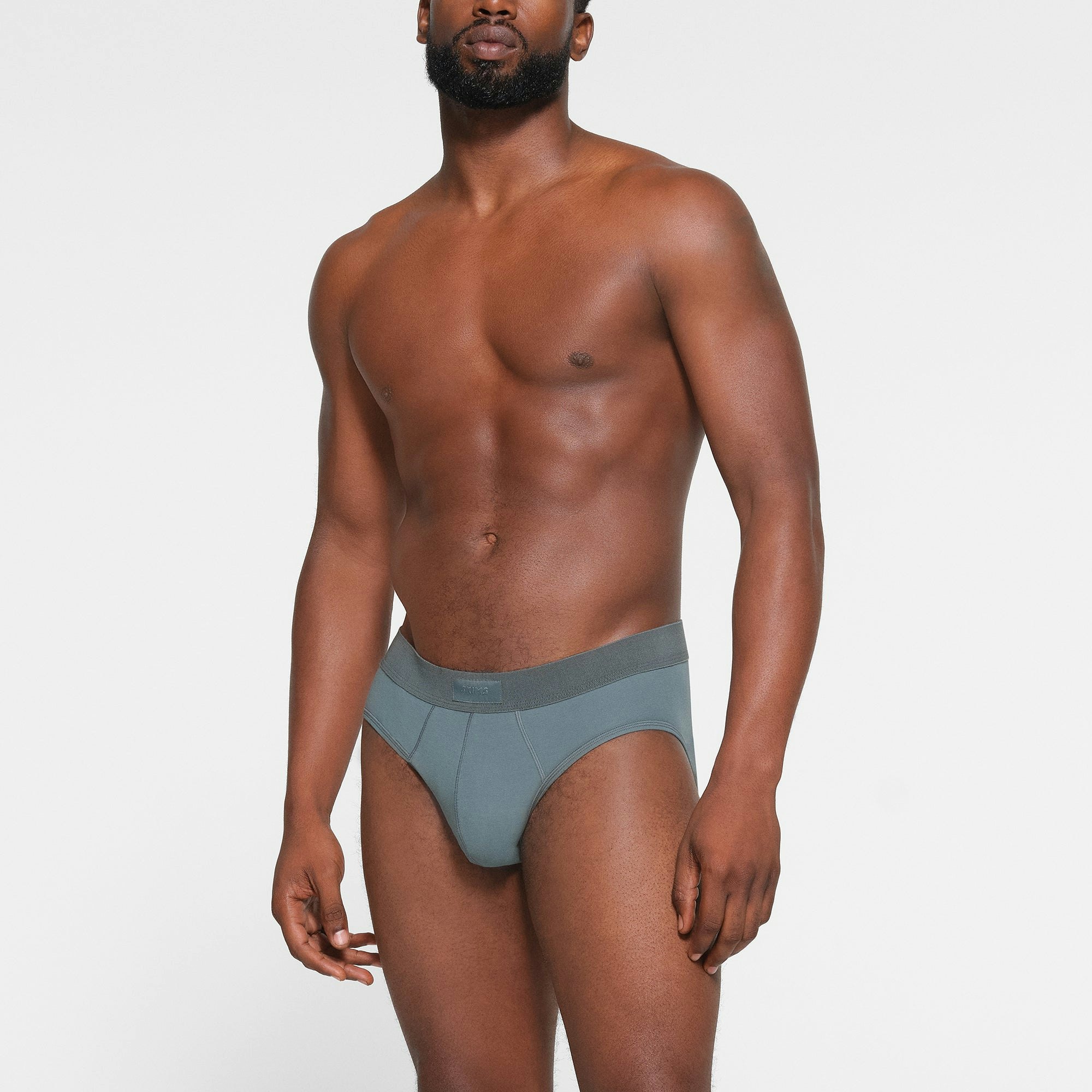 SKIMS COTTON MENS BRIEF 3-PACK WORN BY A MODEL IN FRONT VIEW