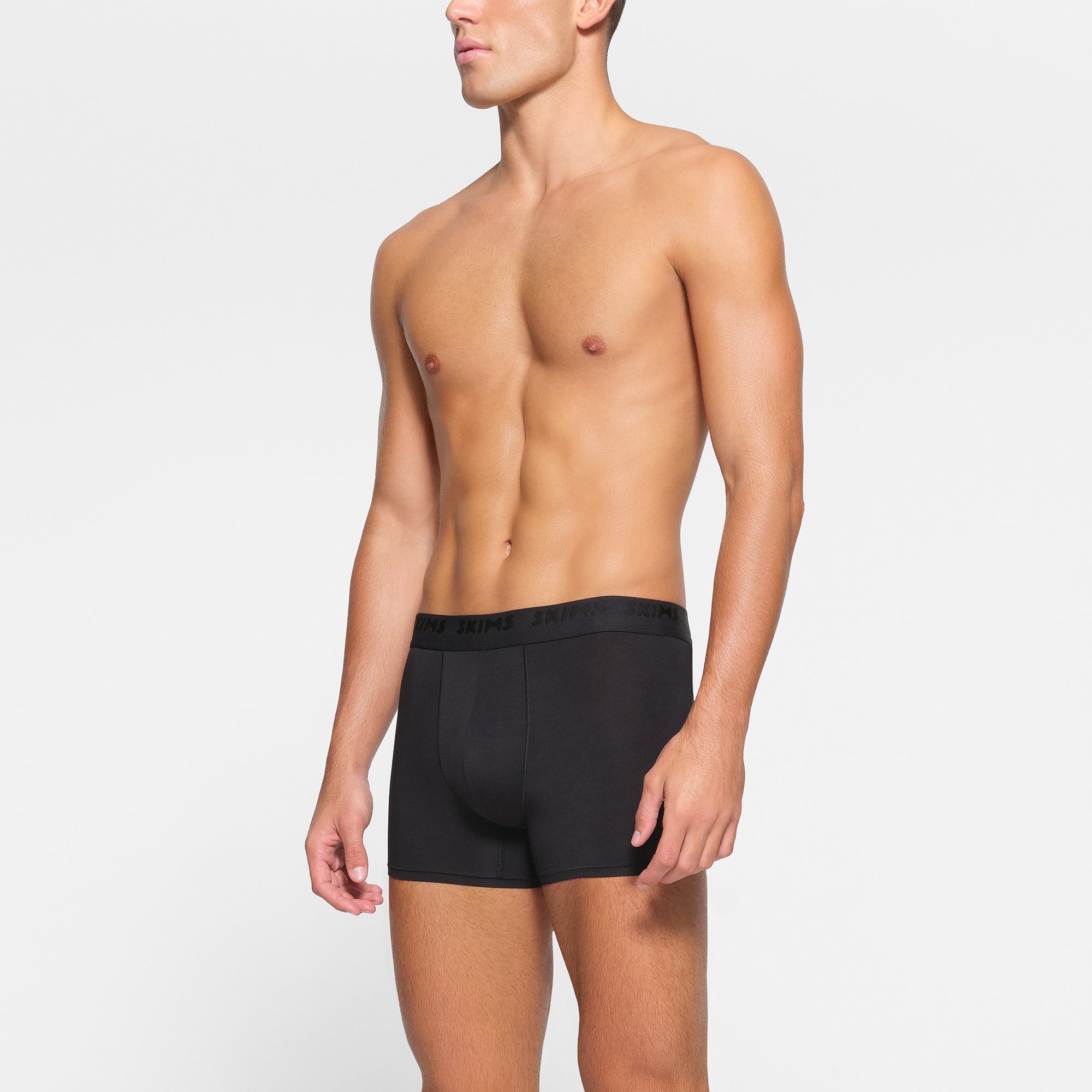 SKIMS STRETCH MENS 3" BOXER BRIEF 3-PACK WORN BY A MODEL IN SIDE VIEW