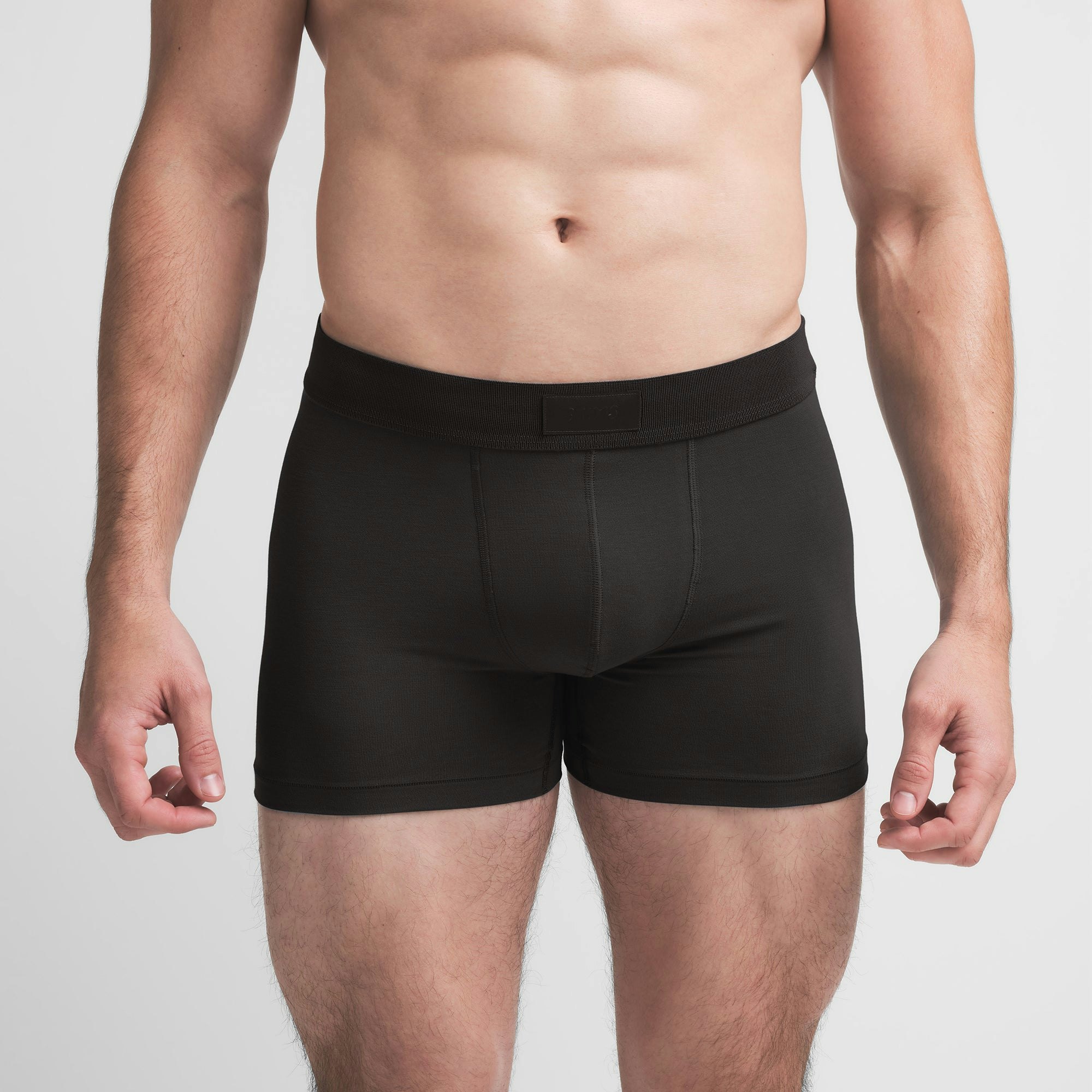 SKIMS COTTON MENS 3" BOXER BRIEF | ONYX ON A MODEL FRONT VIEW @ | FOCUS: 0.9, 0.1, 0.7
