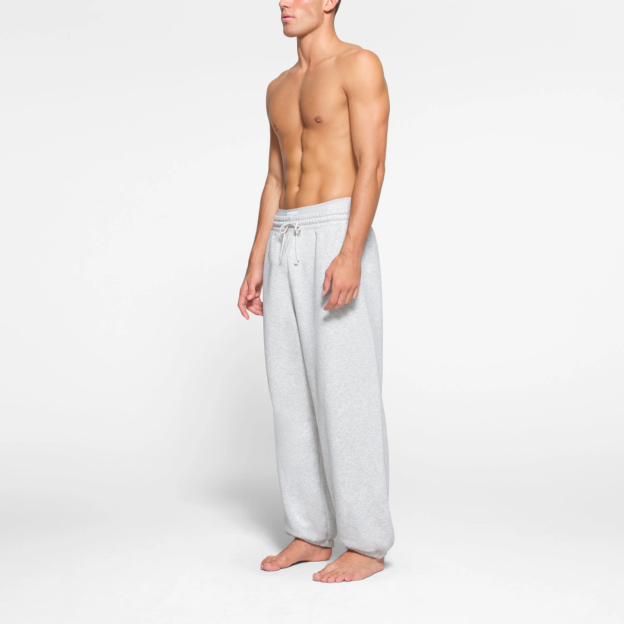 LOUNGE FLEECE MENS RELAXED JOGGER | LIGHT HEATHER GREY ON A MODEL SIDE VIEW