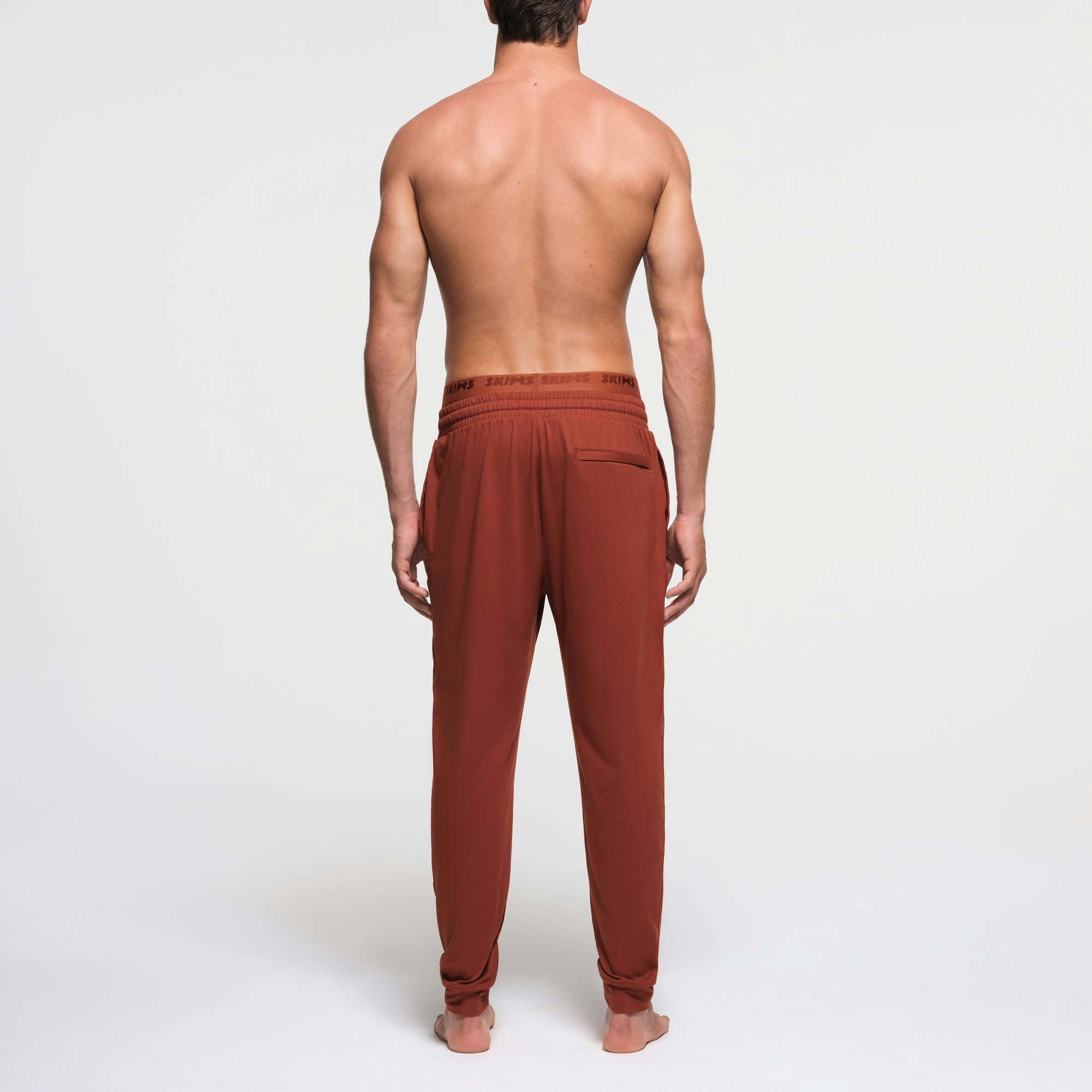 OUTDOOR JERSEY MENS TAPERED JOGGER | RUST ON A MODEL BACK VIEW