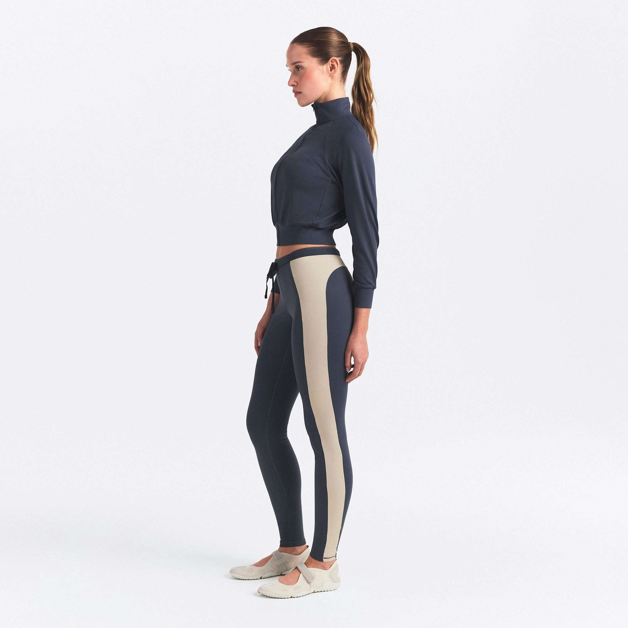 NikeSKIMS MATTE AND SHINE 26" LEGGING | DEEP ROYAL/STONE ON A MODEL SIDE VIEW @ | FOCUS: 0.0, 1.0, 0.9