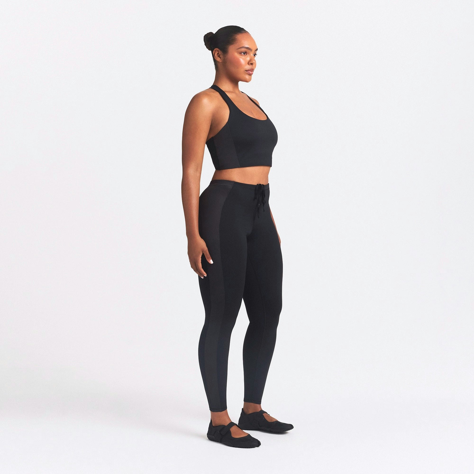 NikeSKIMS MATTE AND SHINE 26" LEGGING | OBSIDIAN/IGNEOUS ON A MODEL SIDE VIEW @ | FOCUS: 0.0, 1.0, 0.9